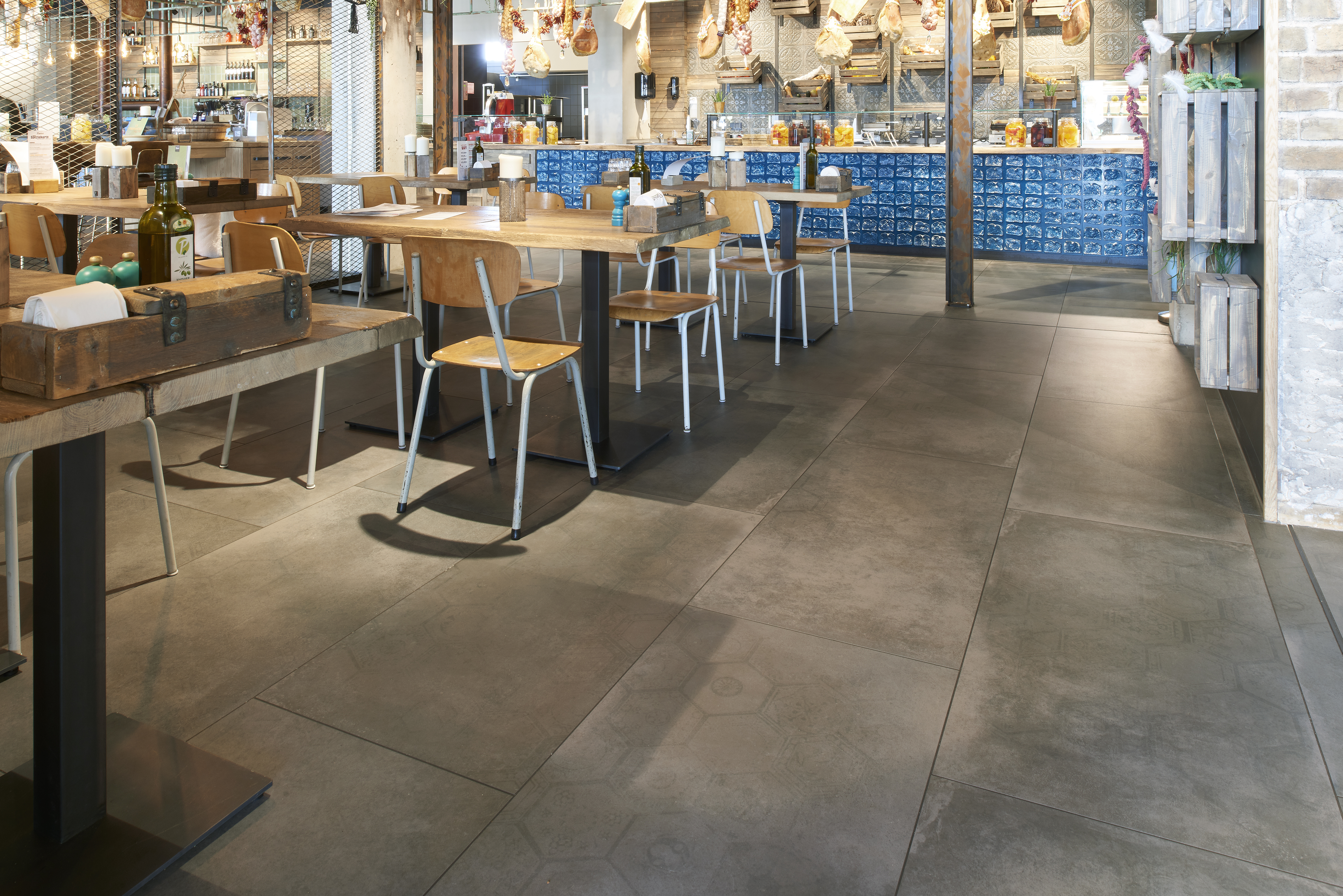 Large-format, dark grey floor tiles in a modern restaurant.