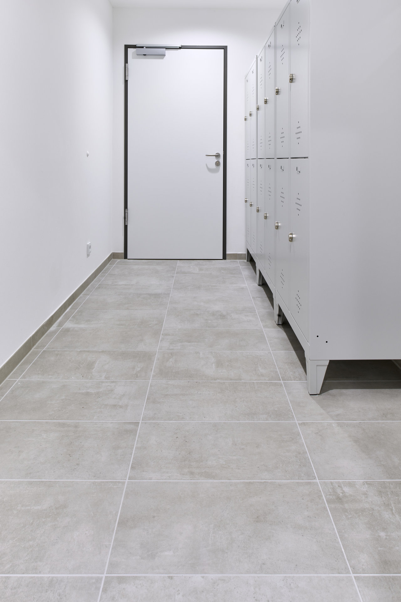 Modern, light grey tiles in a changing room hallway.