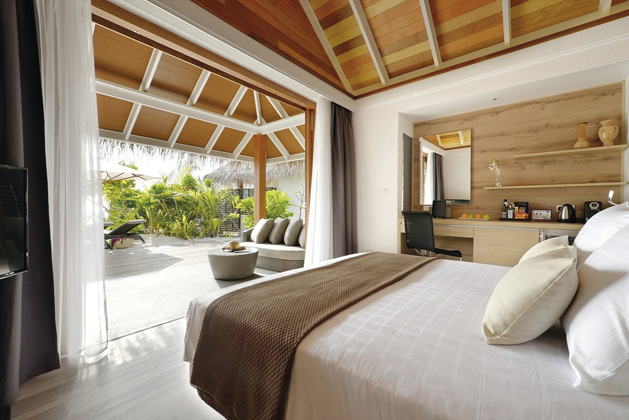 Bright bedroom with modern floor tiles and access to a tiled outdoor terrace.