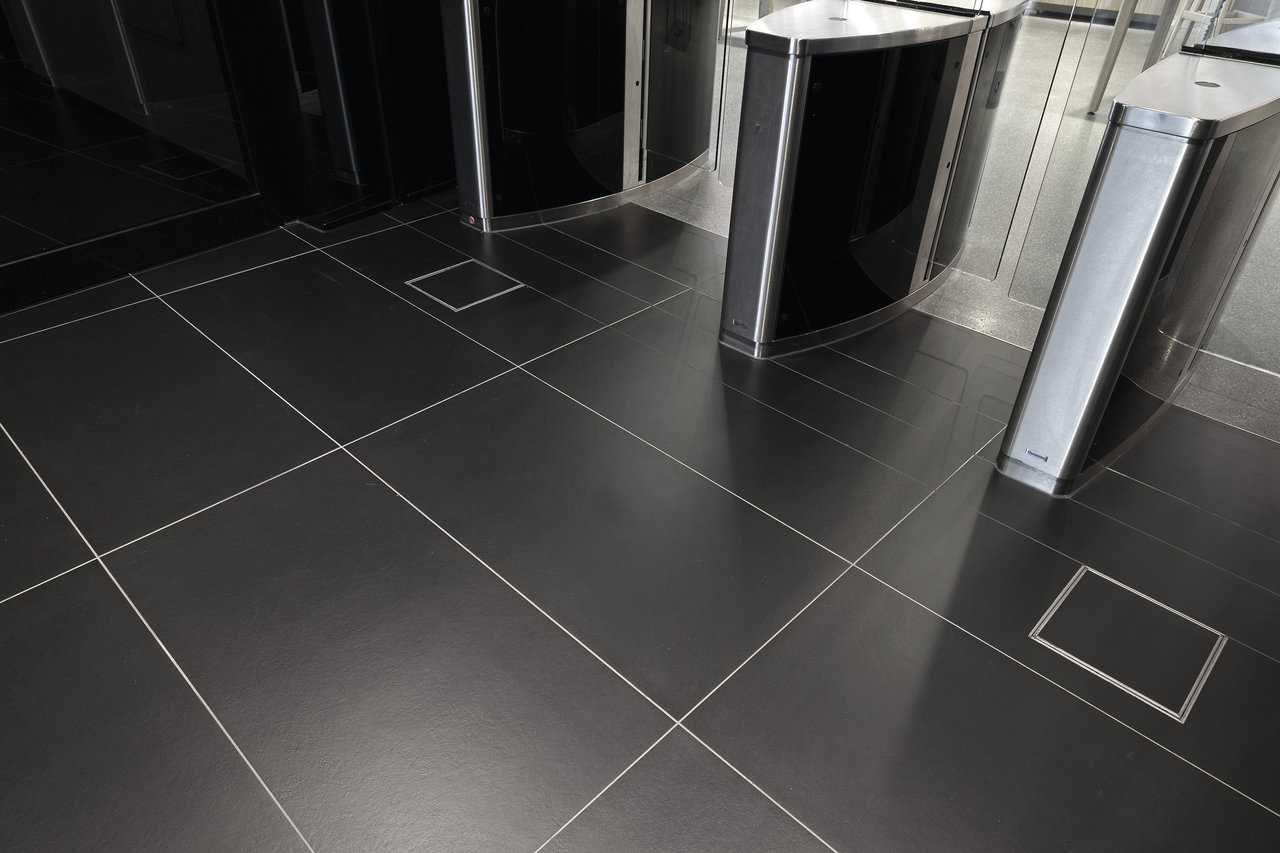 Elegant, large-format anthracite tiles with light grout in a foyer.