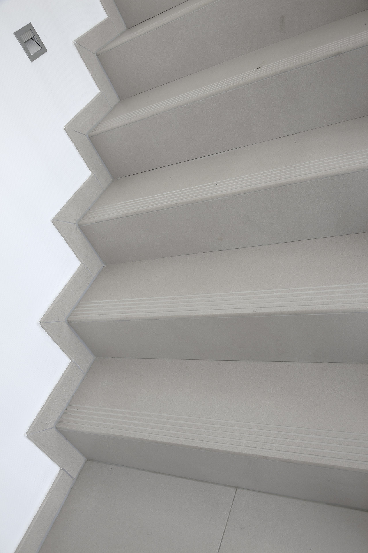 Modern light grey concrete-effect tile staircase with non-slip nosing.