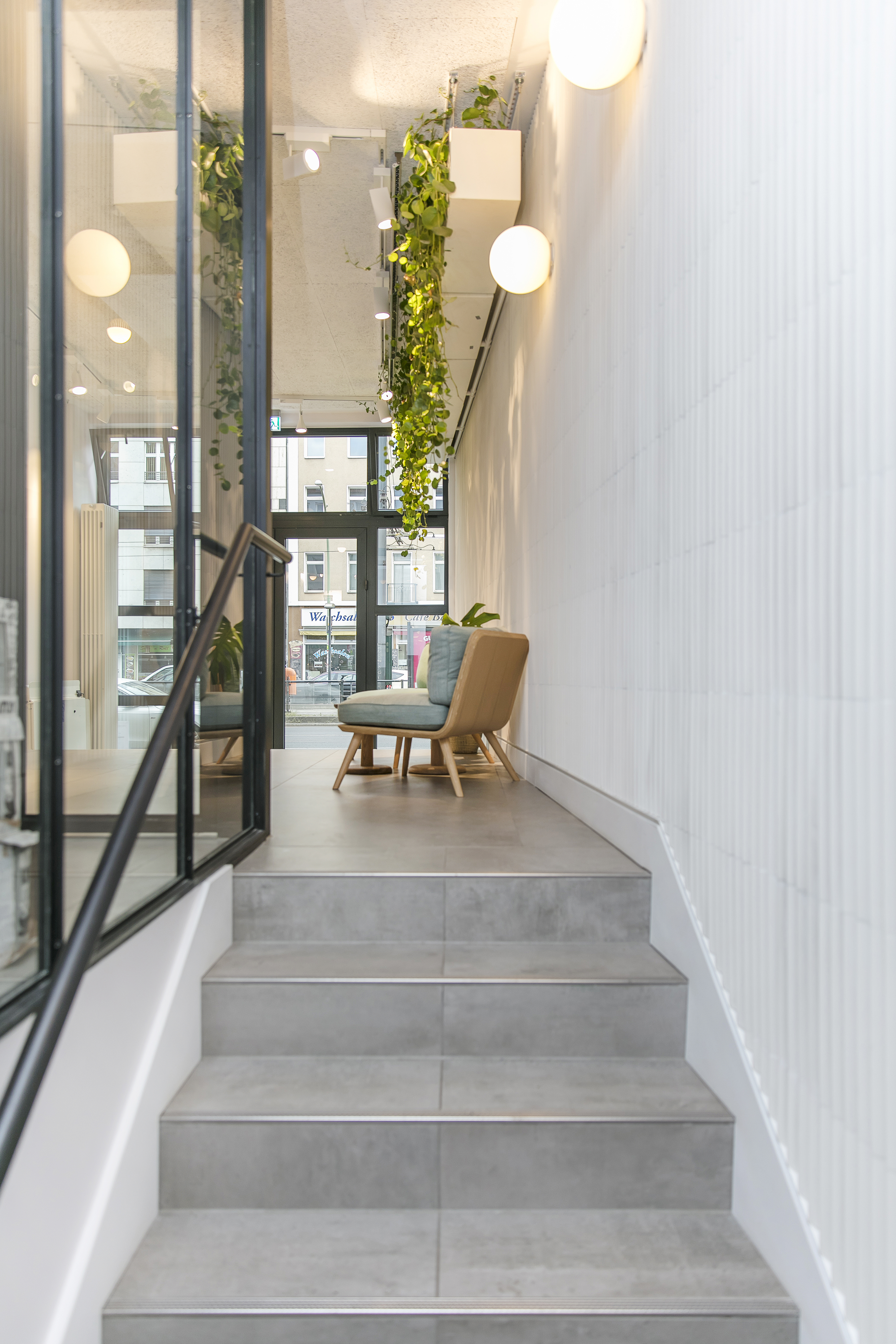 Modern grey stair and floor tiles, combined with textured white wall tiles.