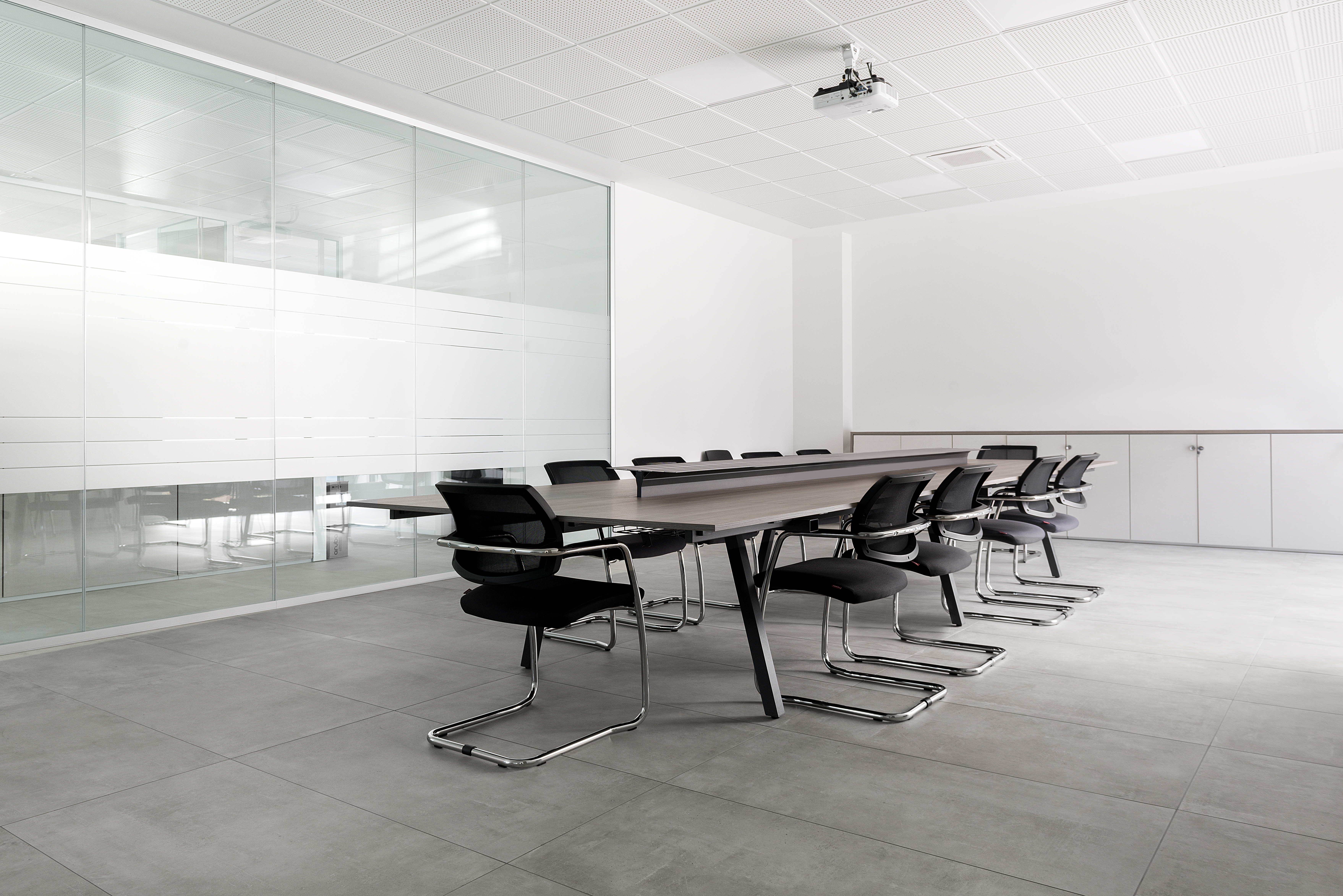 Large-format grey tiles in a modern conference room.