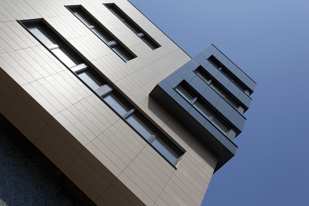 Modern building facade with light and dark tiles, perfect for outdoor areas.