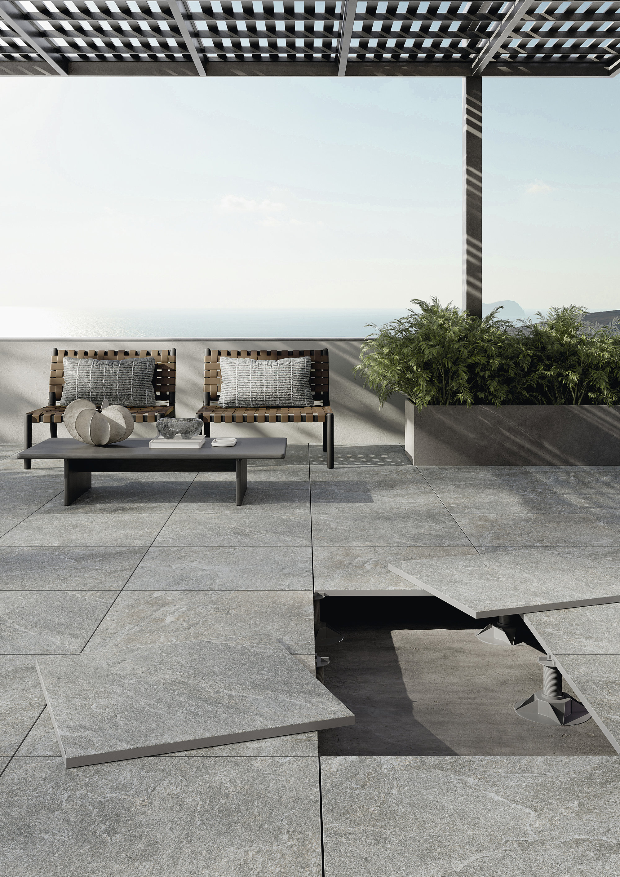 Grey outdoor tiles on a modern terrace with sea view; partially open tiles show the substructure.