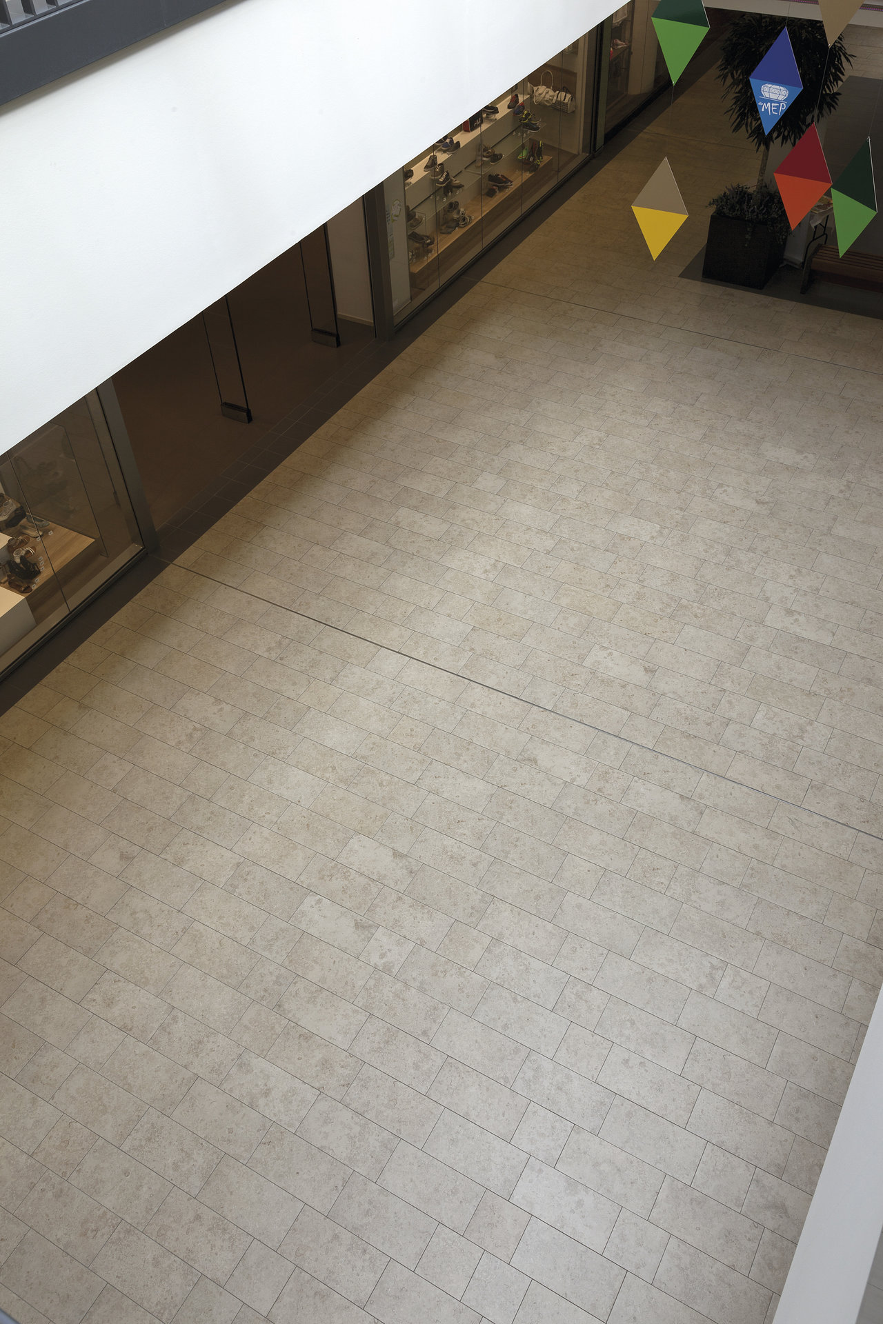 High-quality indoor tiles in light beige, laid in a half-bond pattern.