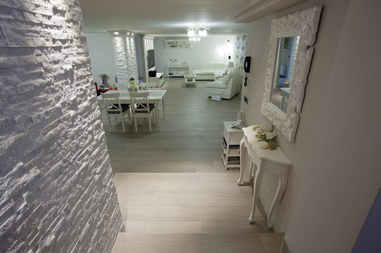 Modern living area with light wood-look tiles.