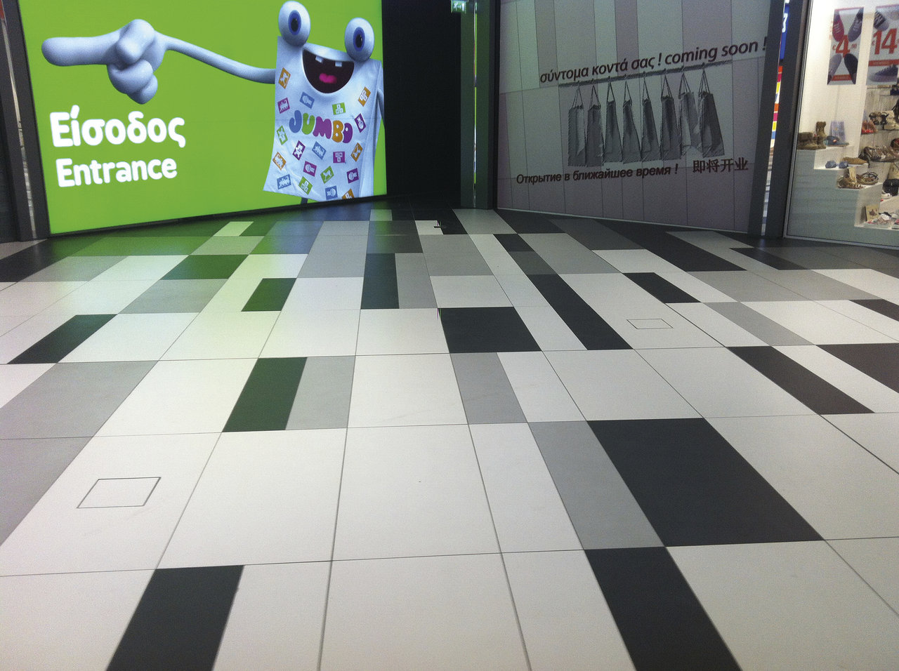 Modern tiled floor in black, white and various shades of grey with a geometric pattern.