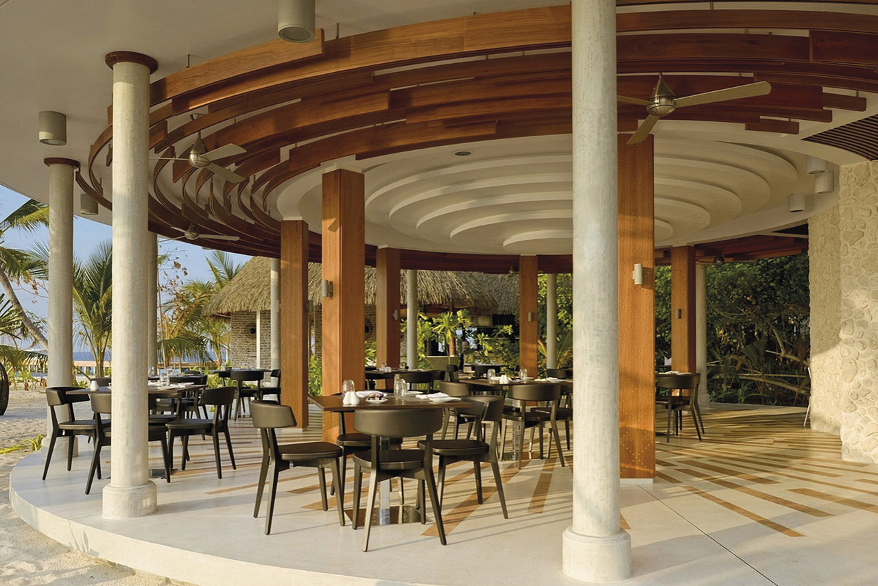 Elegant outdoor lounge with light floor tiles and tropical ambiance.