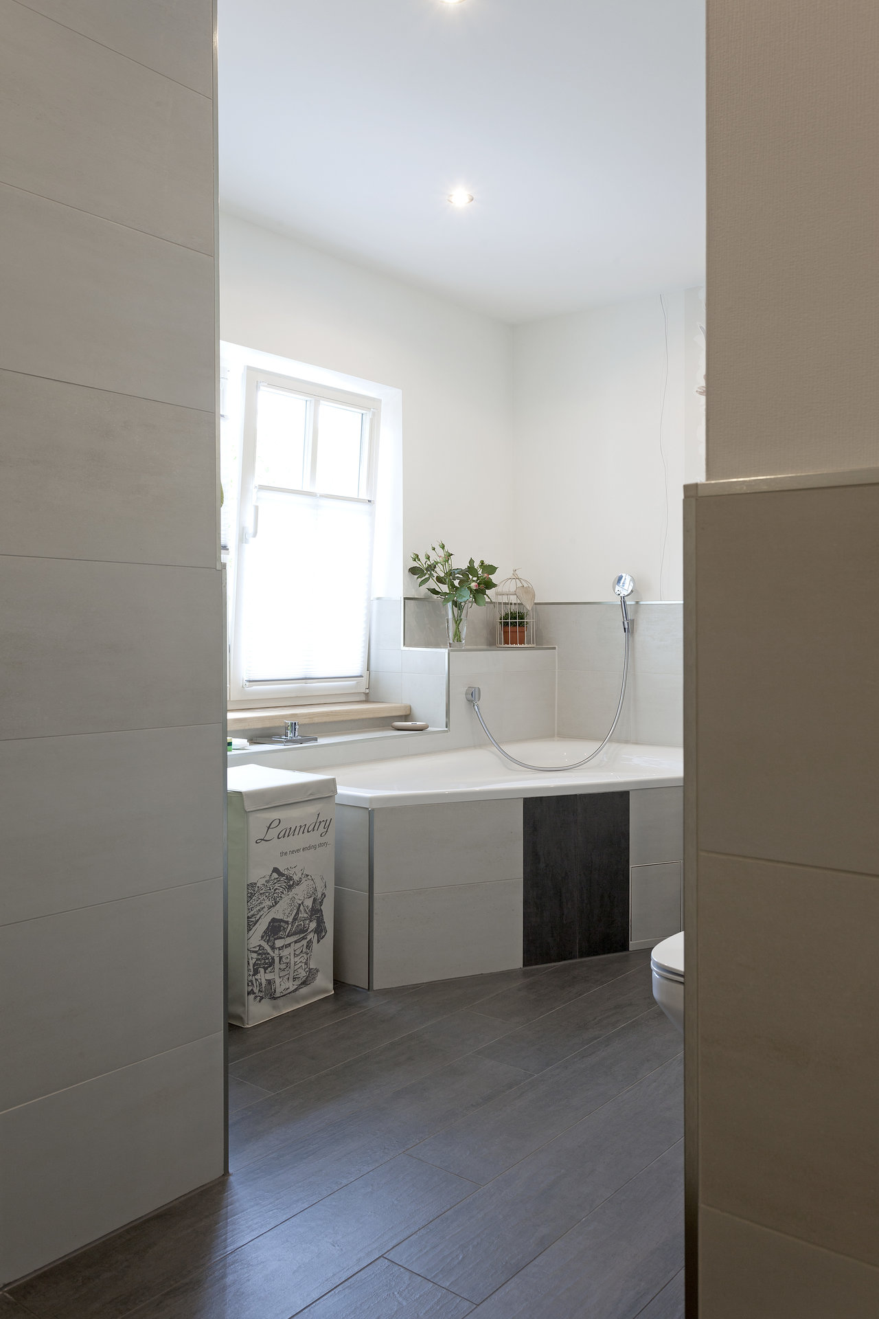 Modern bathroom with anthracite floor tiles and light grey wall tiles.