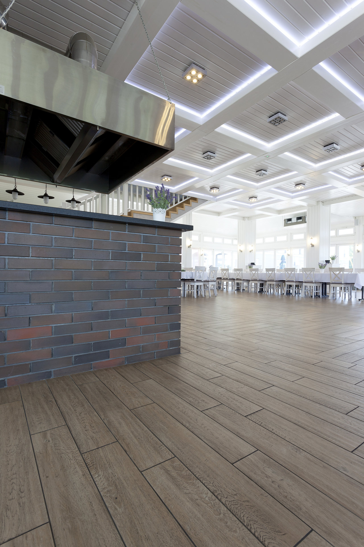 Bright dining area with elegant wood-effect tiles and a brick-look counter.