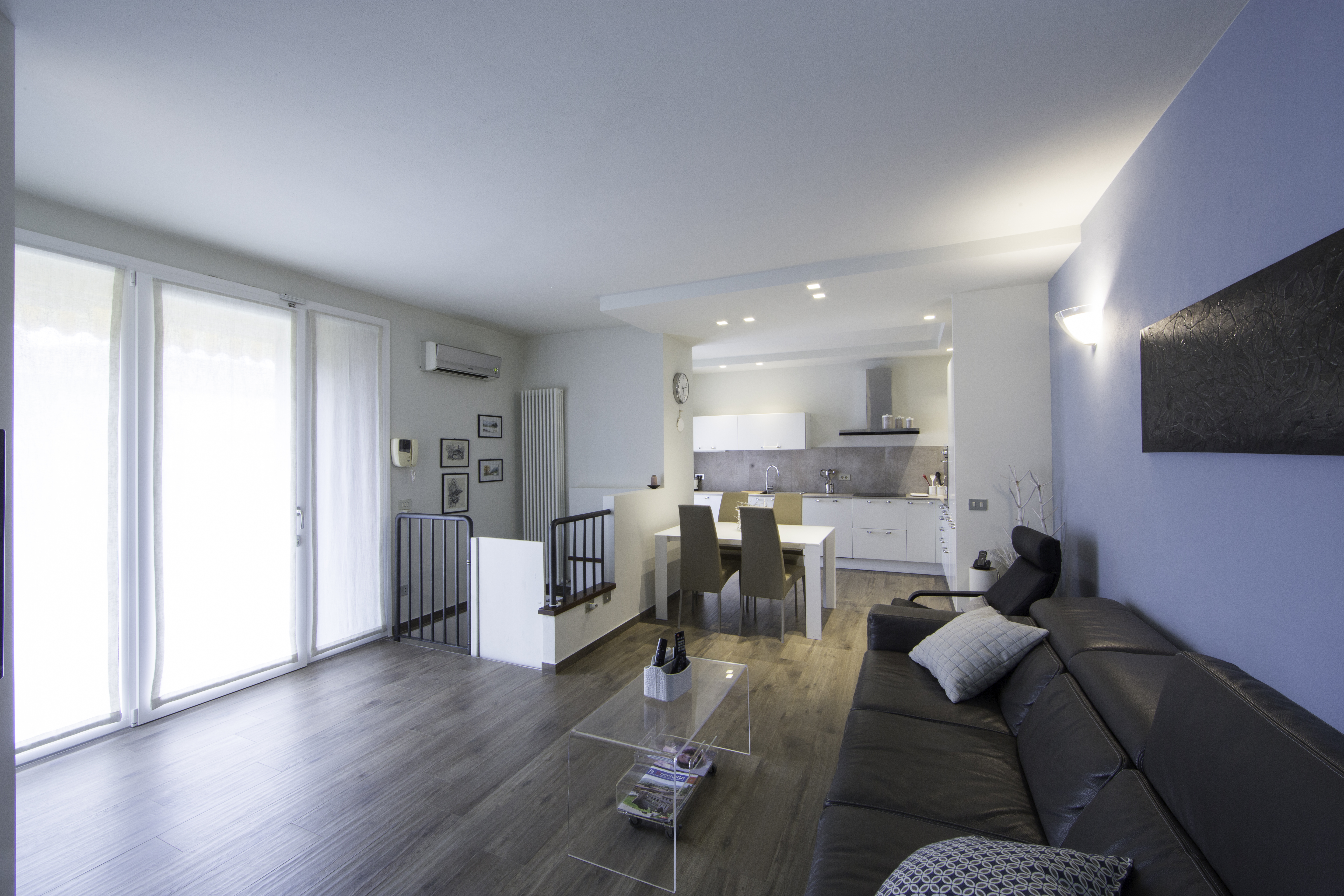 Modern living area with high-quality wood-look tiles, sofa, and dining area.