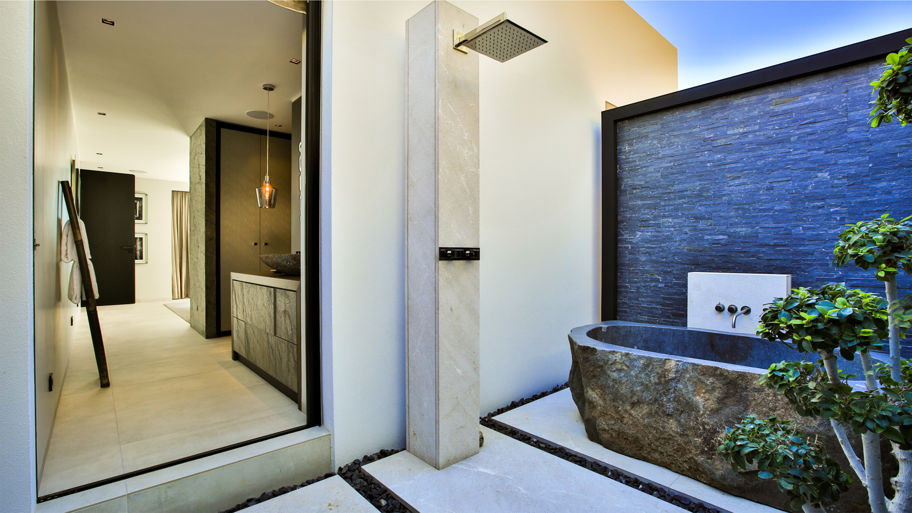 Stylish outdoor area with shower, natural stone tub, and high-quality Porcelaingres outdoor tiles.