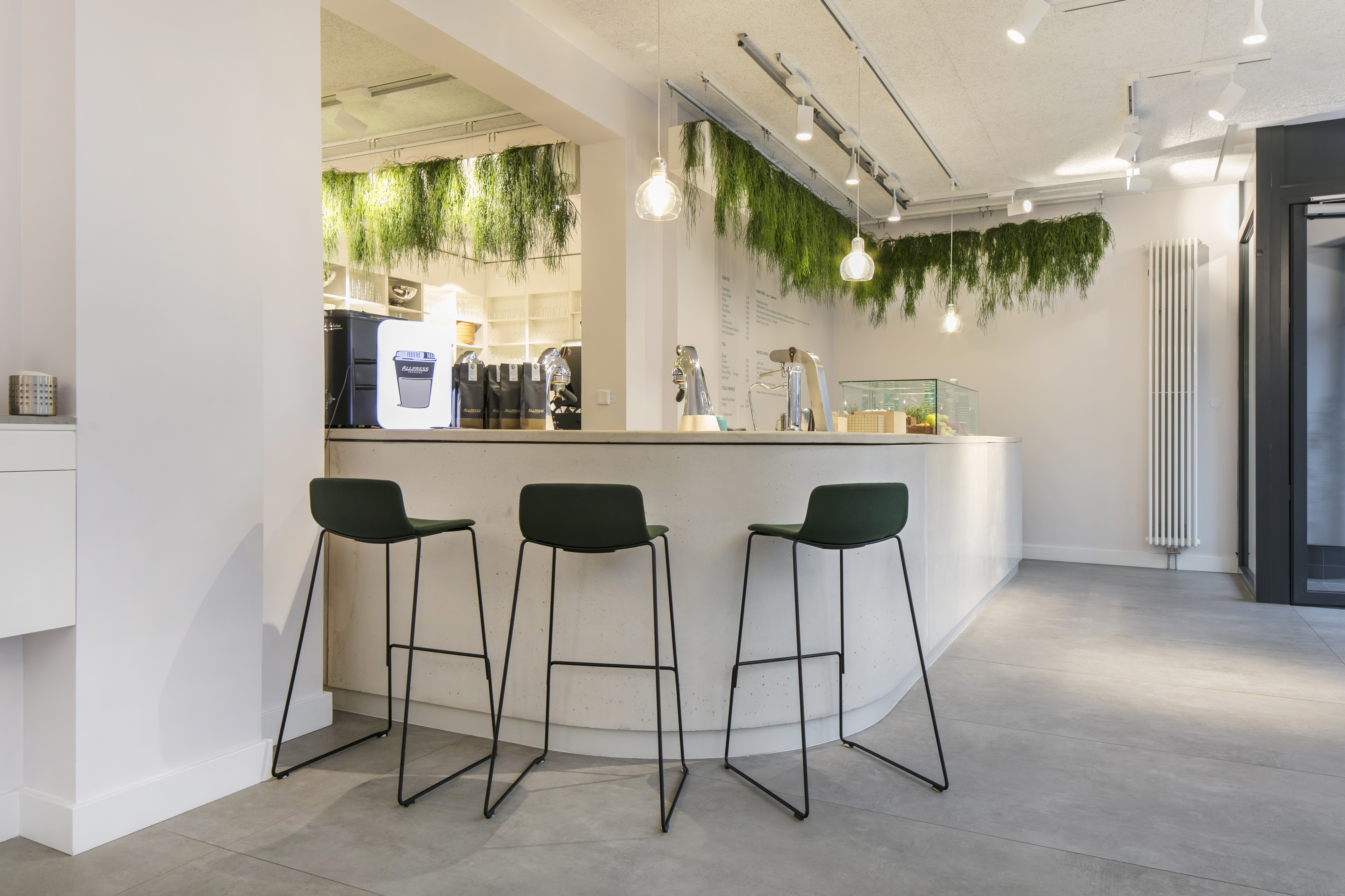Bright, modern lobby with concrete-look floor tiles and stylish bar.