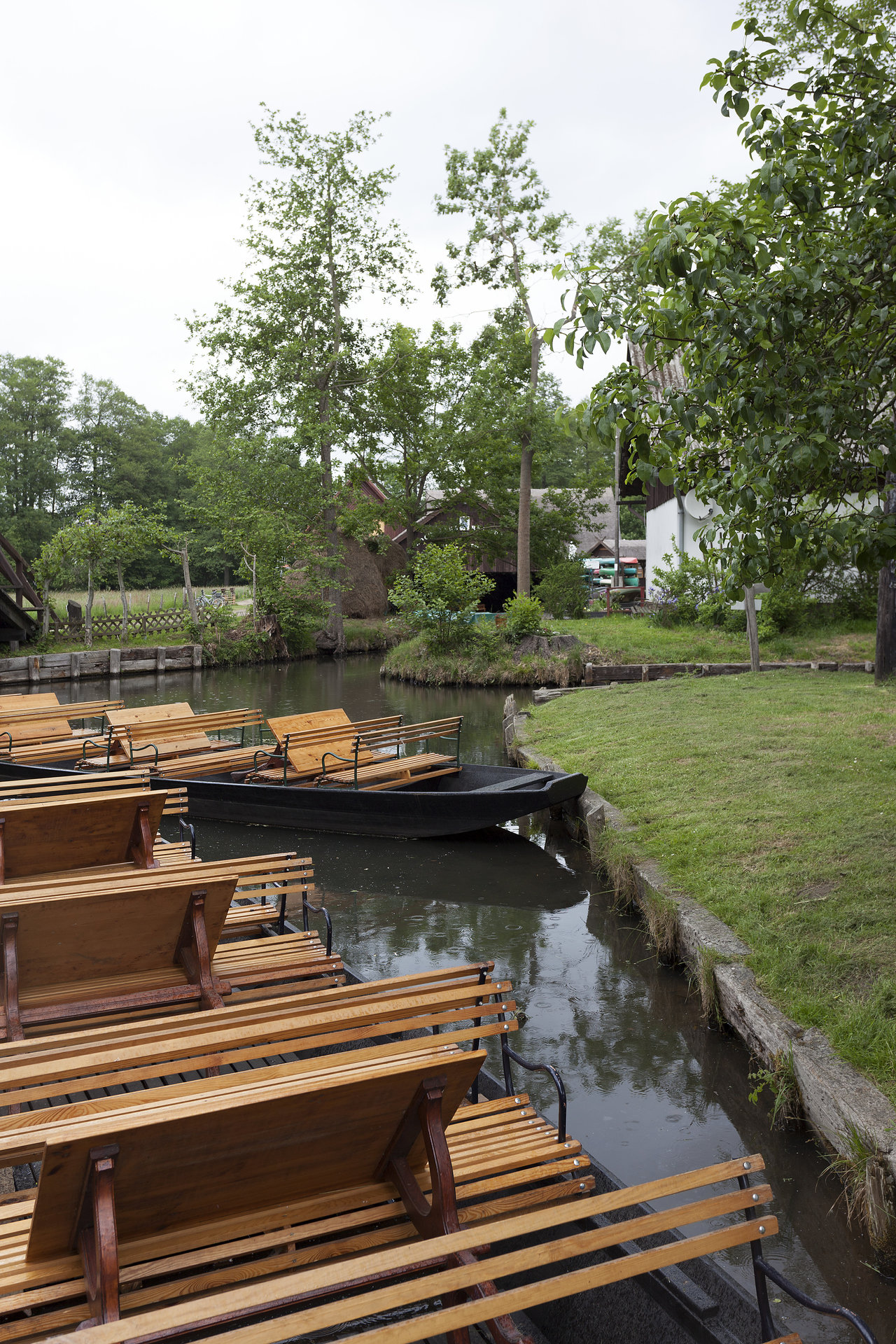 Idyllic river landscape with traditional wooden boats and green banks.
