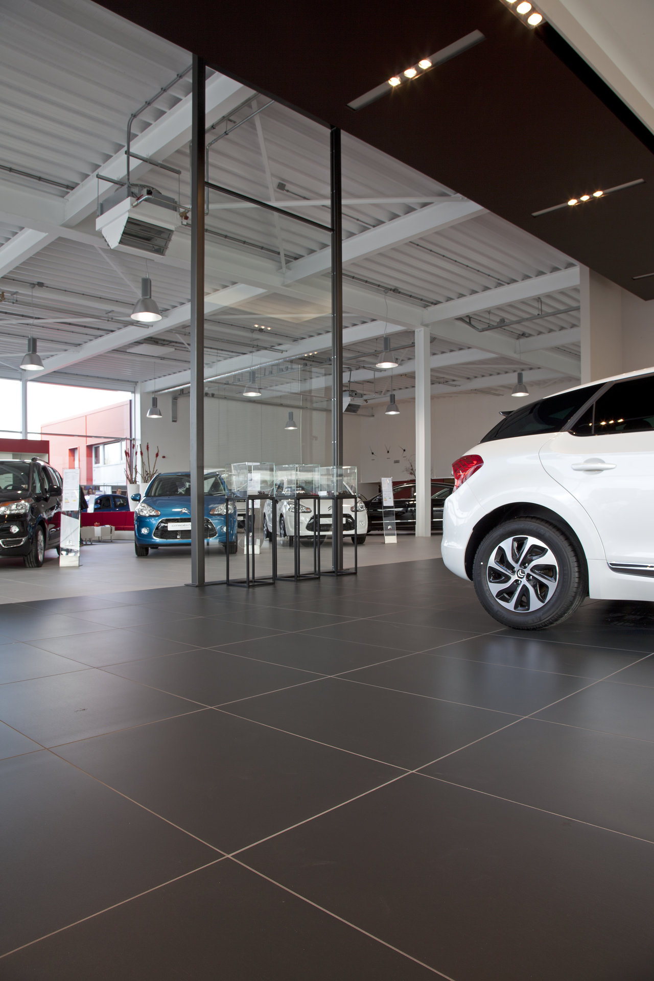Premium large-format anthracite tiles as car dealership flooring.