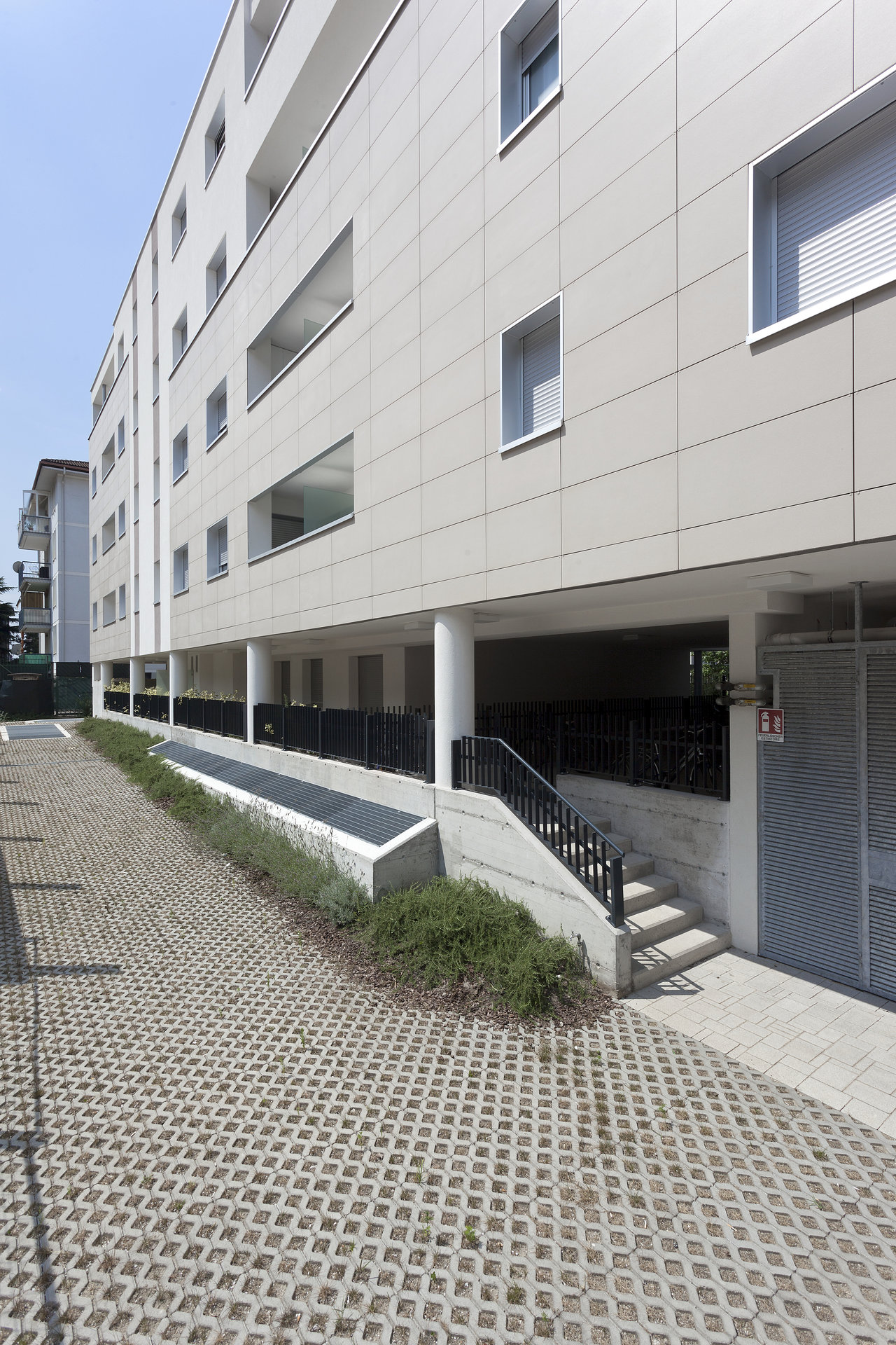 Modern outdoor area with grass pavers and a bright tile facade.