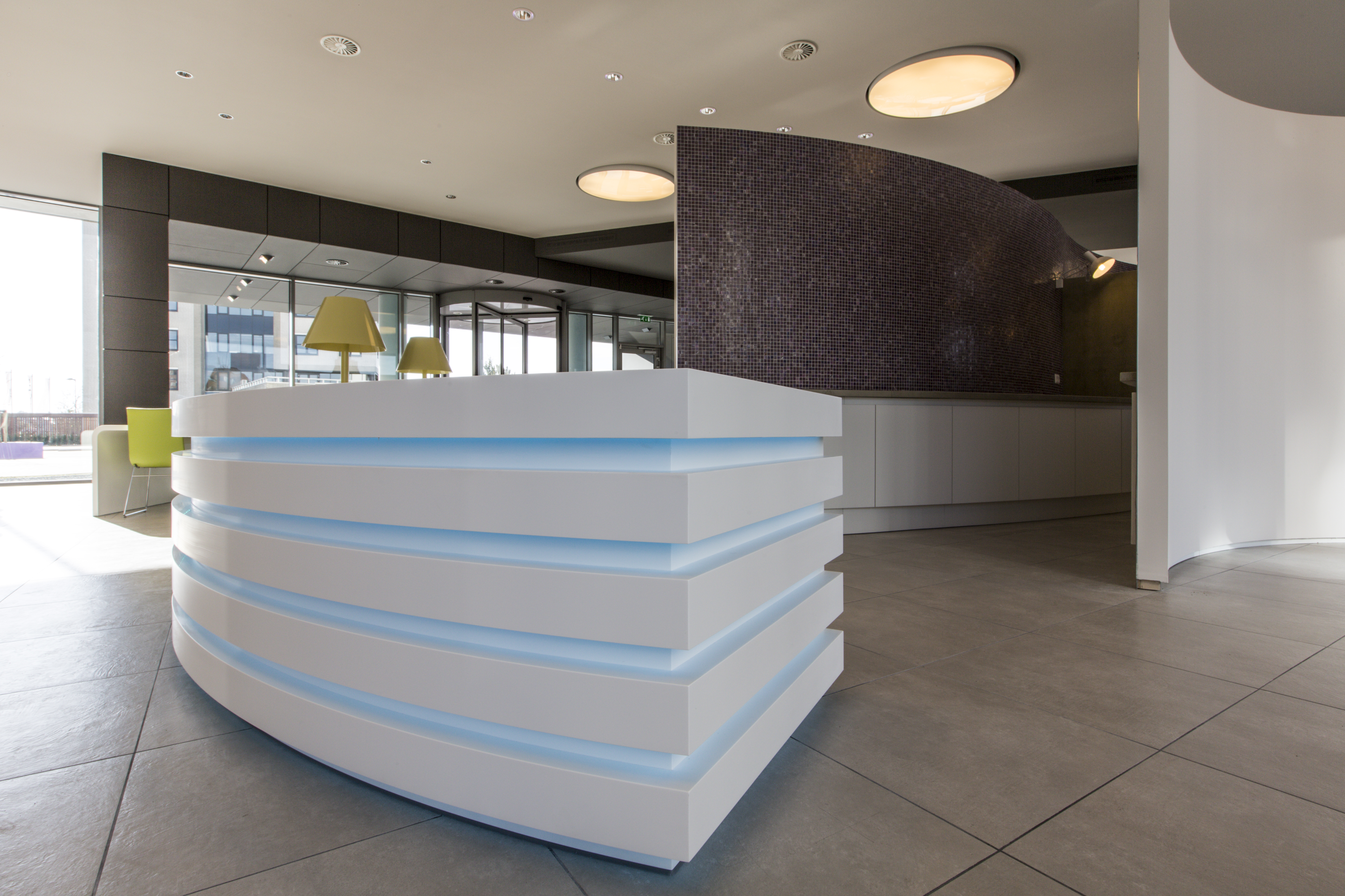 Modern reception area with light grey floor tiles and dark wall cladding.