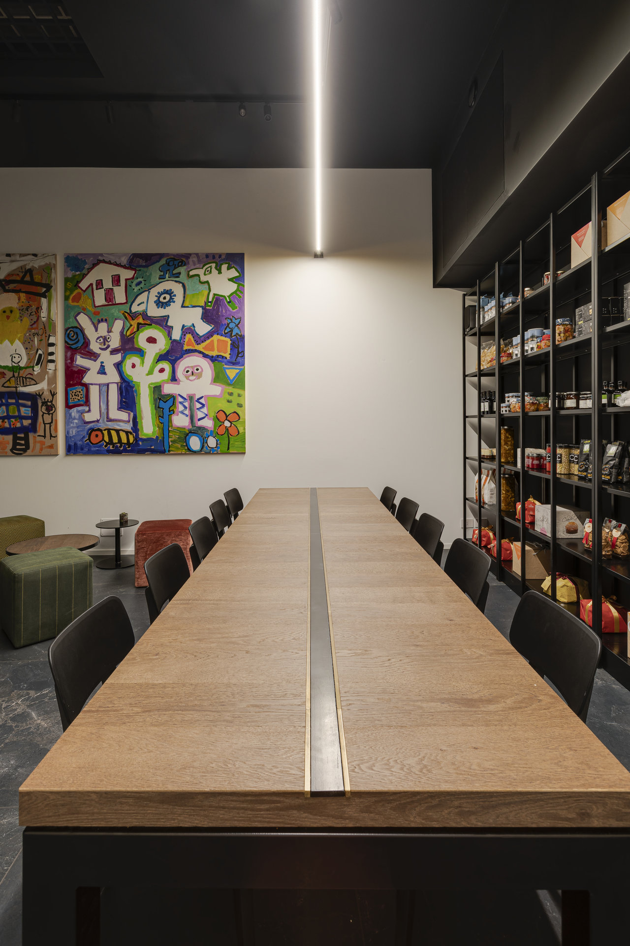 Modern room with long wooden table, wall art, and dark floor, matching high-quality tiles.
