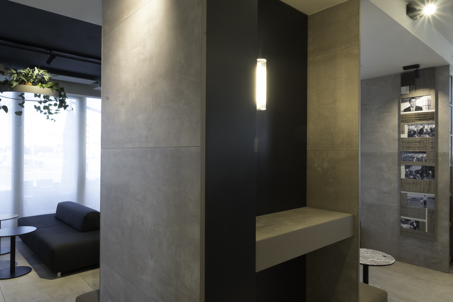 Grey concrete-look tiles by Porcelaingres or Schöner Wohnen on walls and pillar in modern interior.