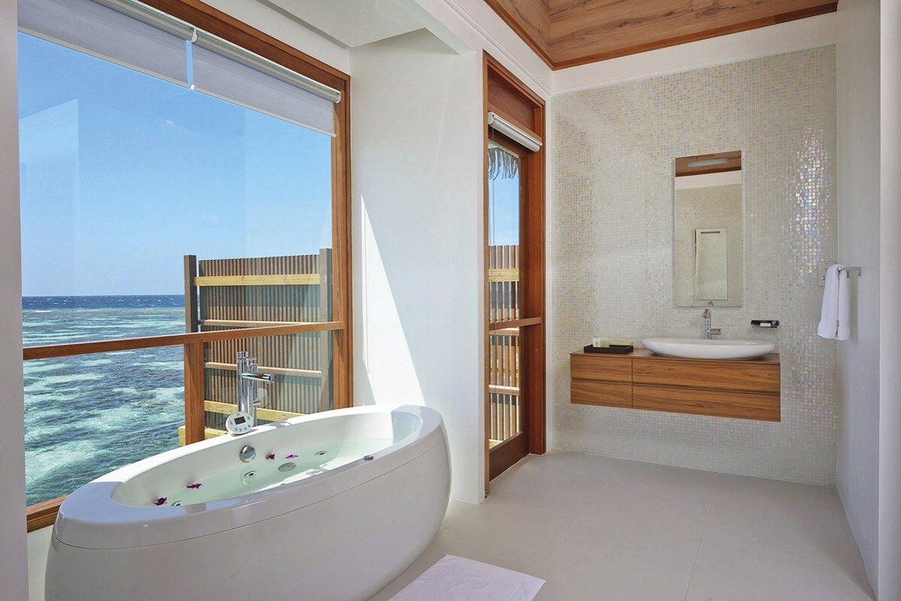 Dream bathroom with sea view, freestanding bath and stylish wall tiles.