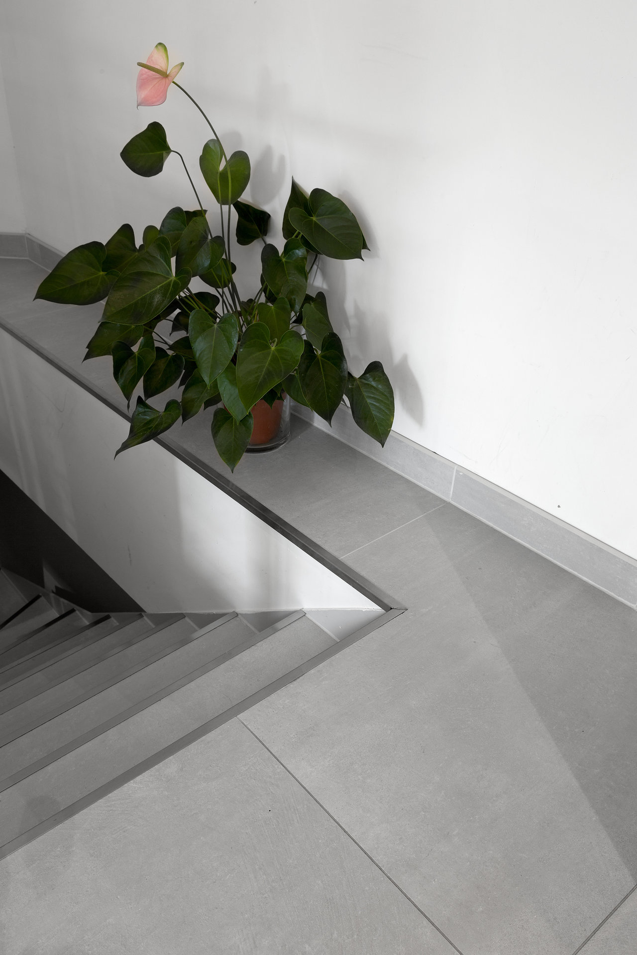 Modern light grey tiles on indoor floor, counter, and stairs.