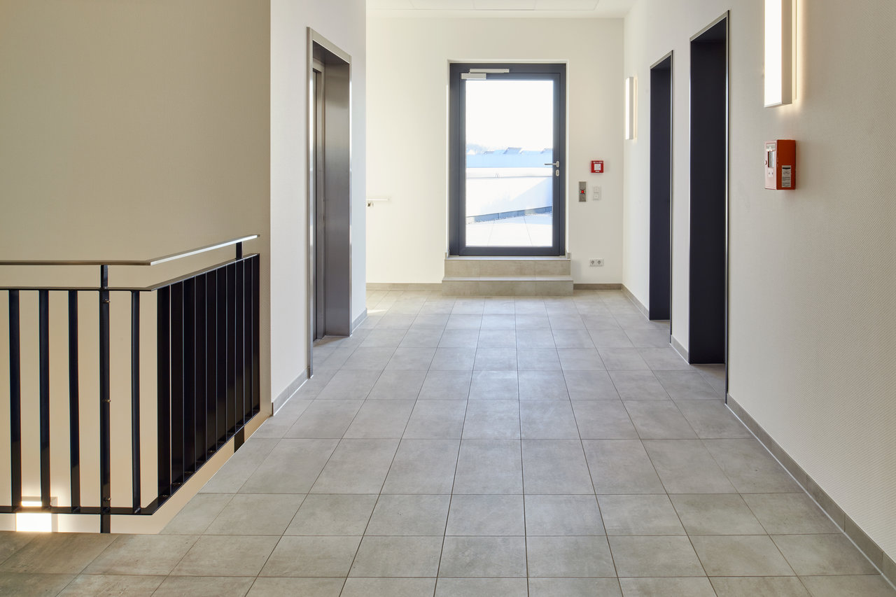 Spacious hallway with high-quality, light grey floor tiles.