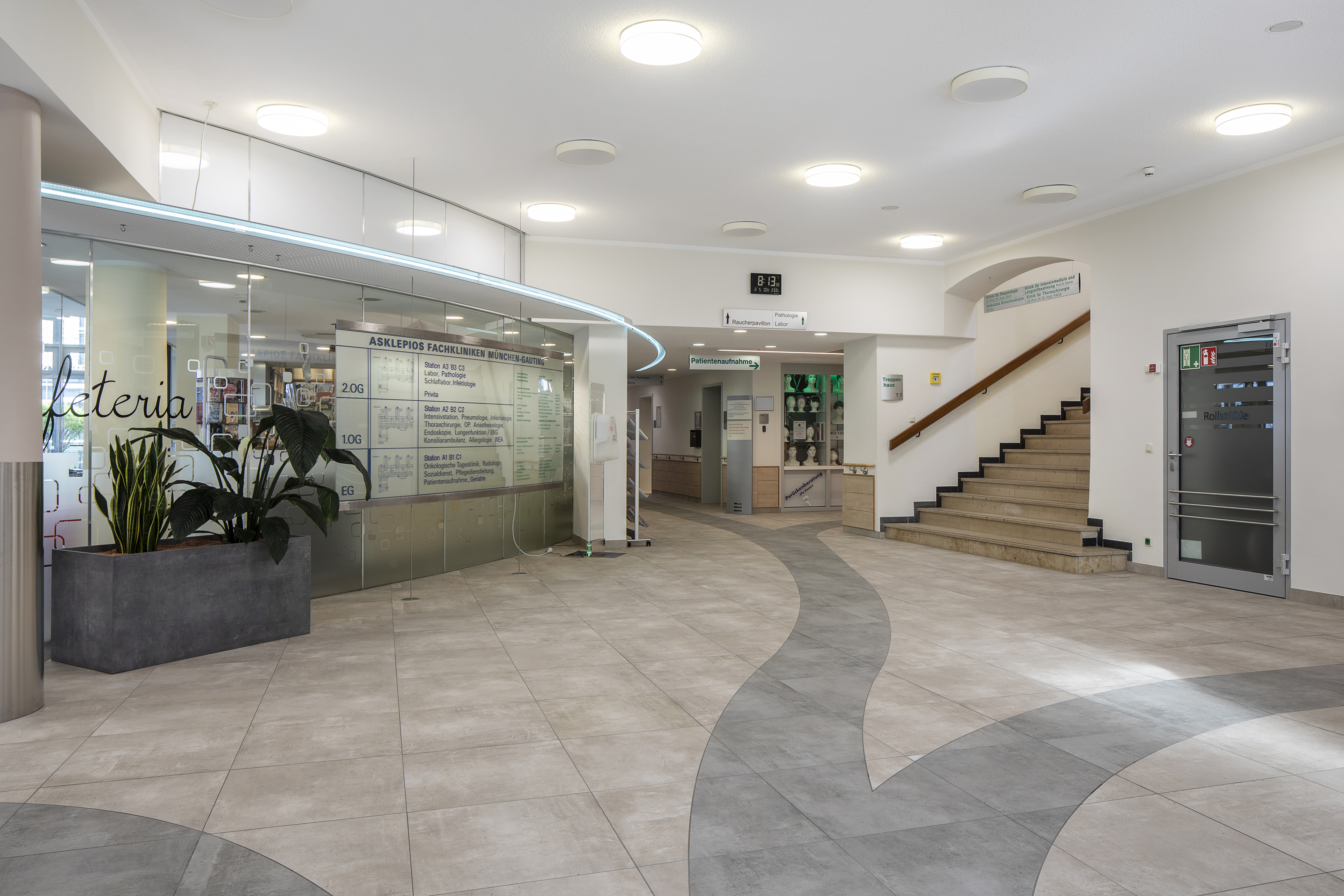 Bright entrance area with modern grey floor tiles and a curved pattern.