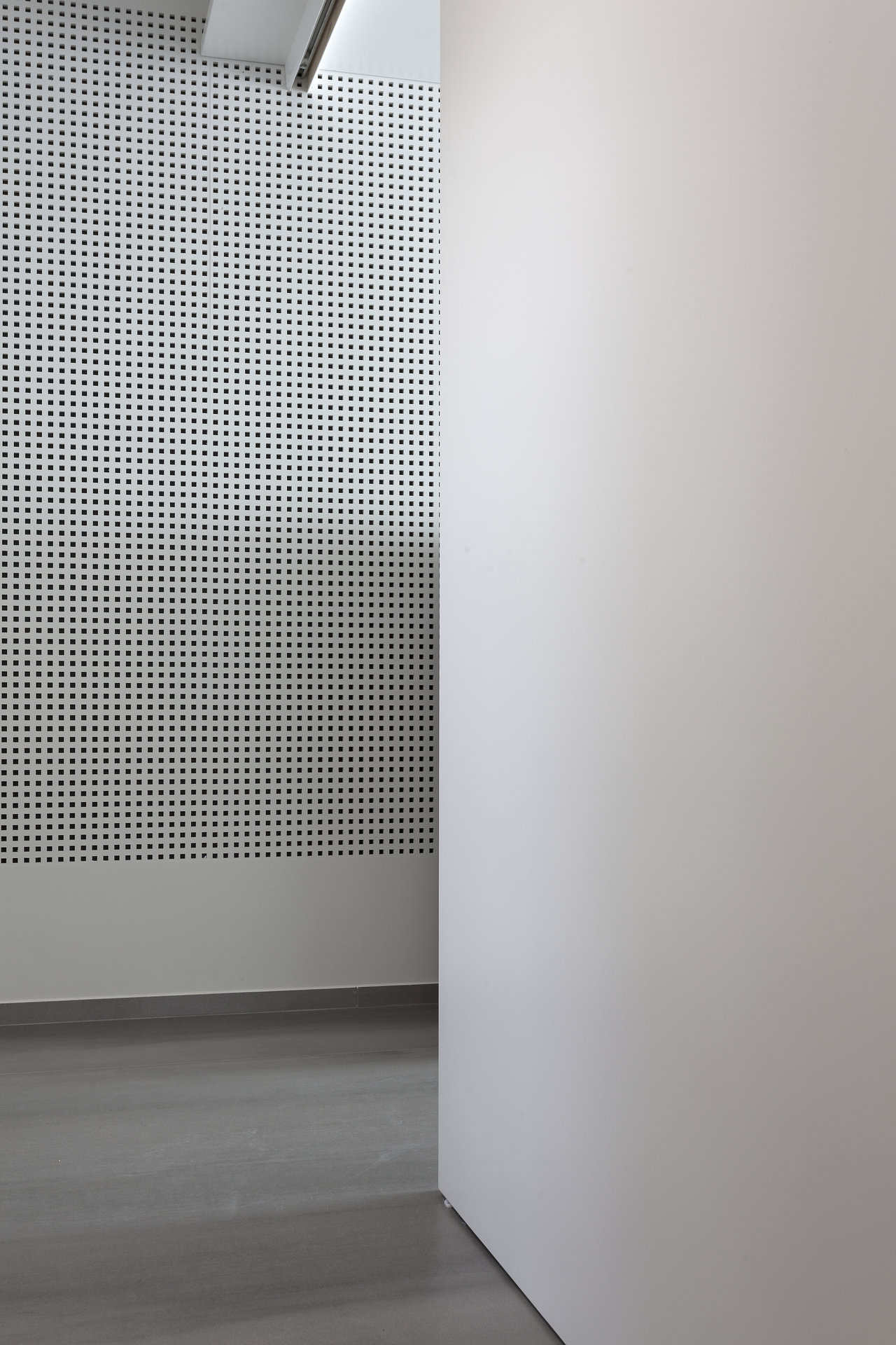 Contemporary design: Grey floor tiles and white wall with fine dot pattern.
