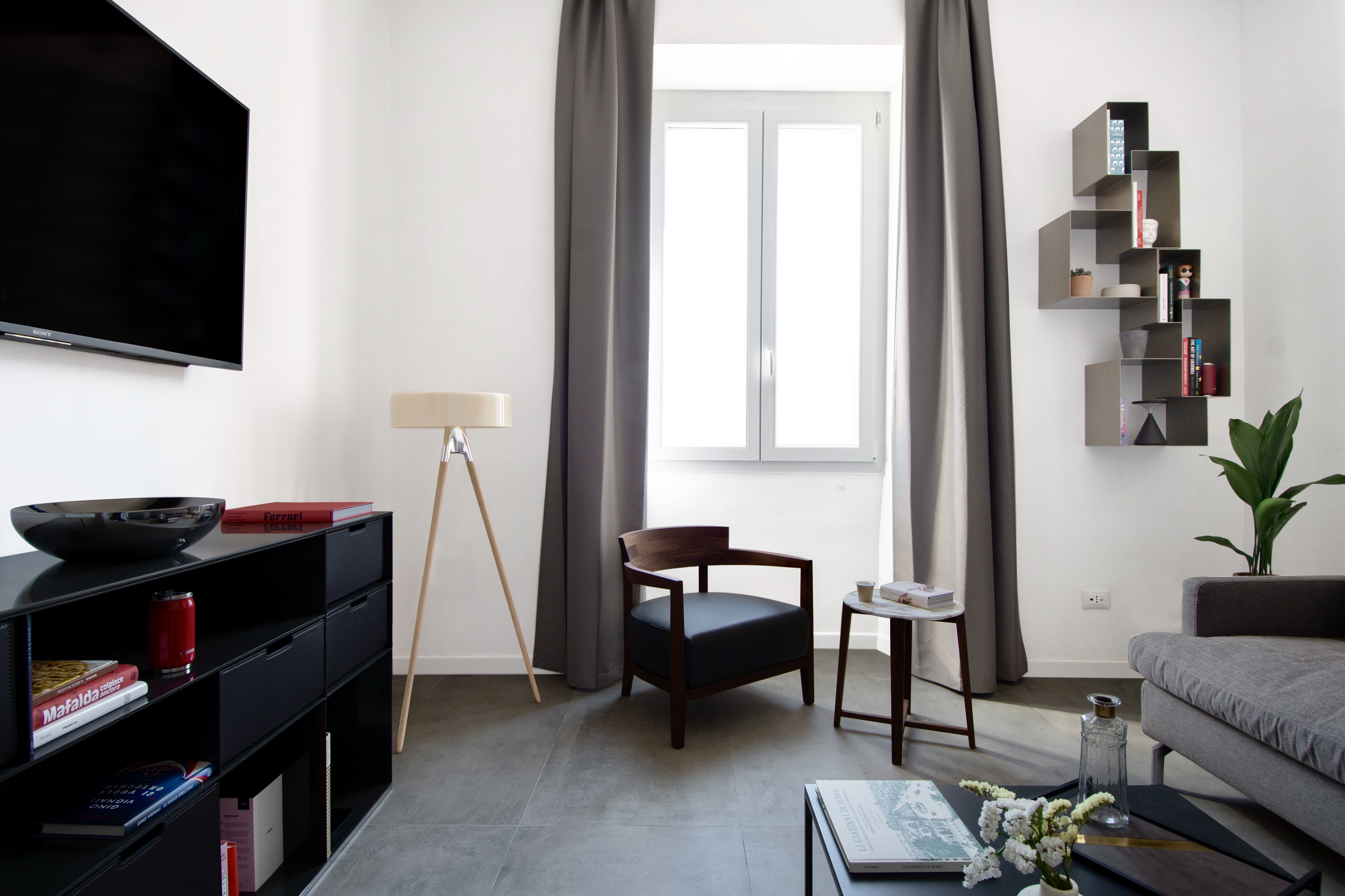 Modern living room with dark, large-format floor tiles.