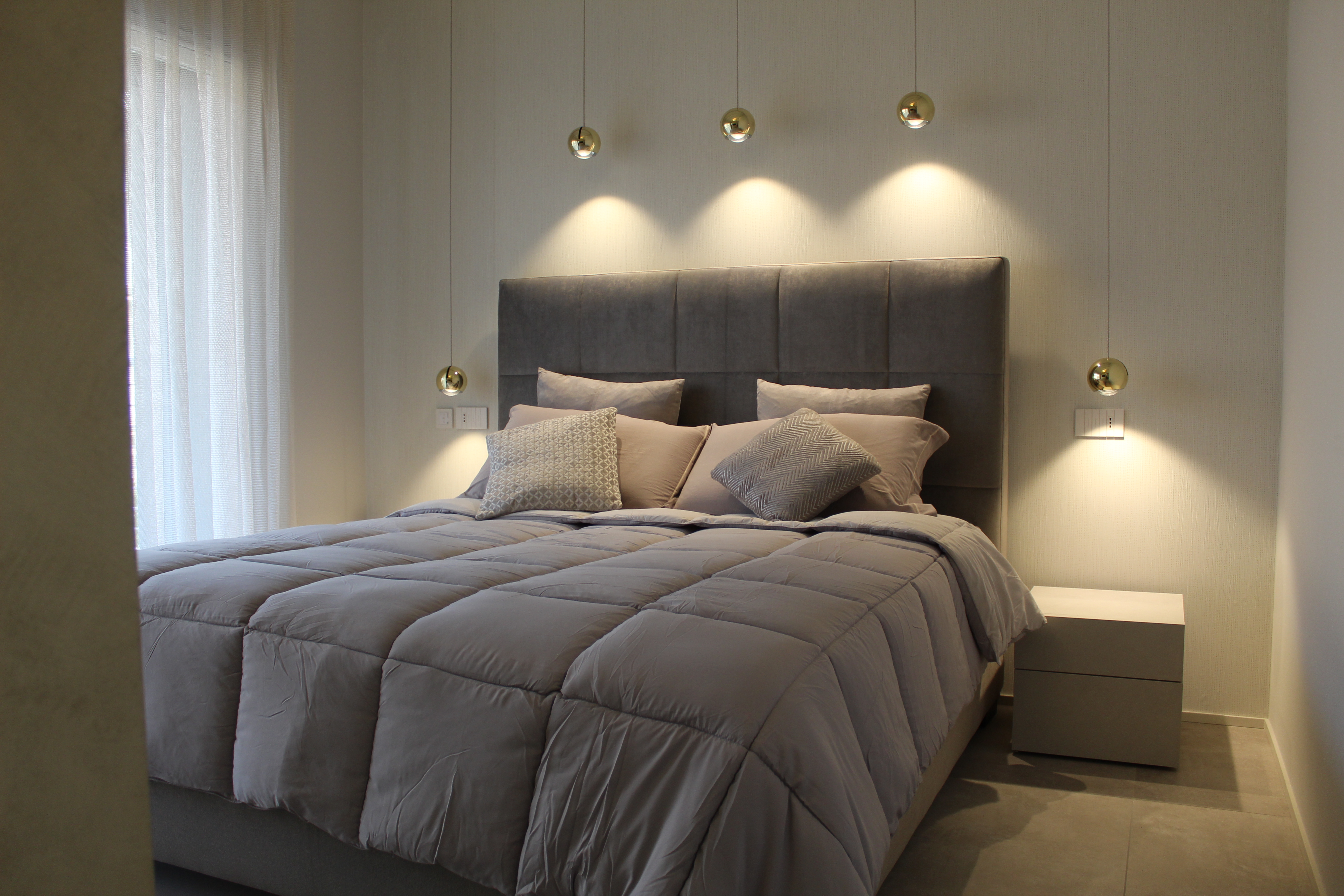 Modern bedroom with high-quality grey floor tiles.