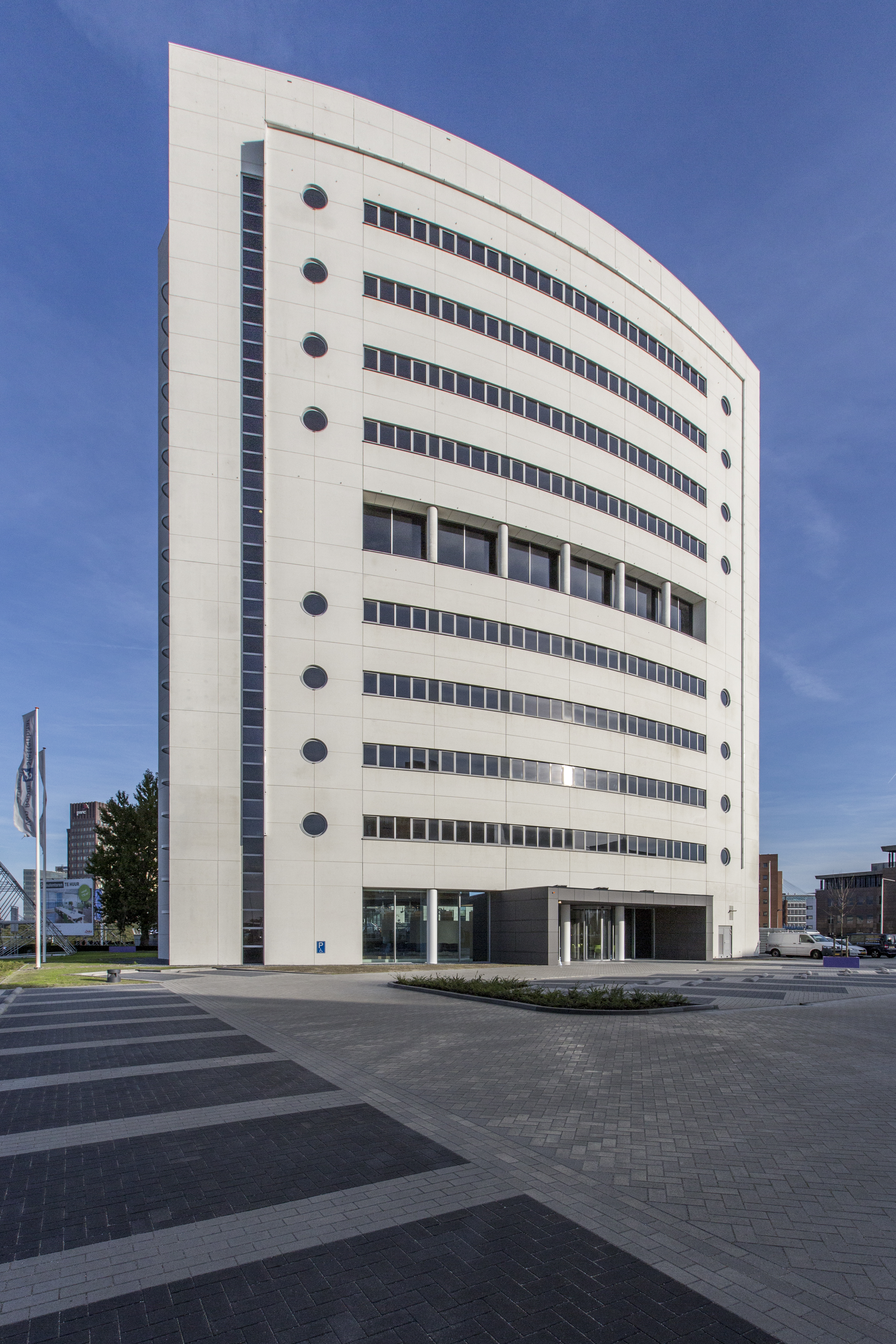 Spacious area with modern outdoor tiles in grey tones in front of an elegant building.