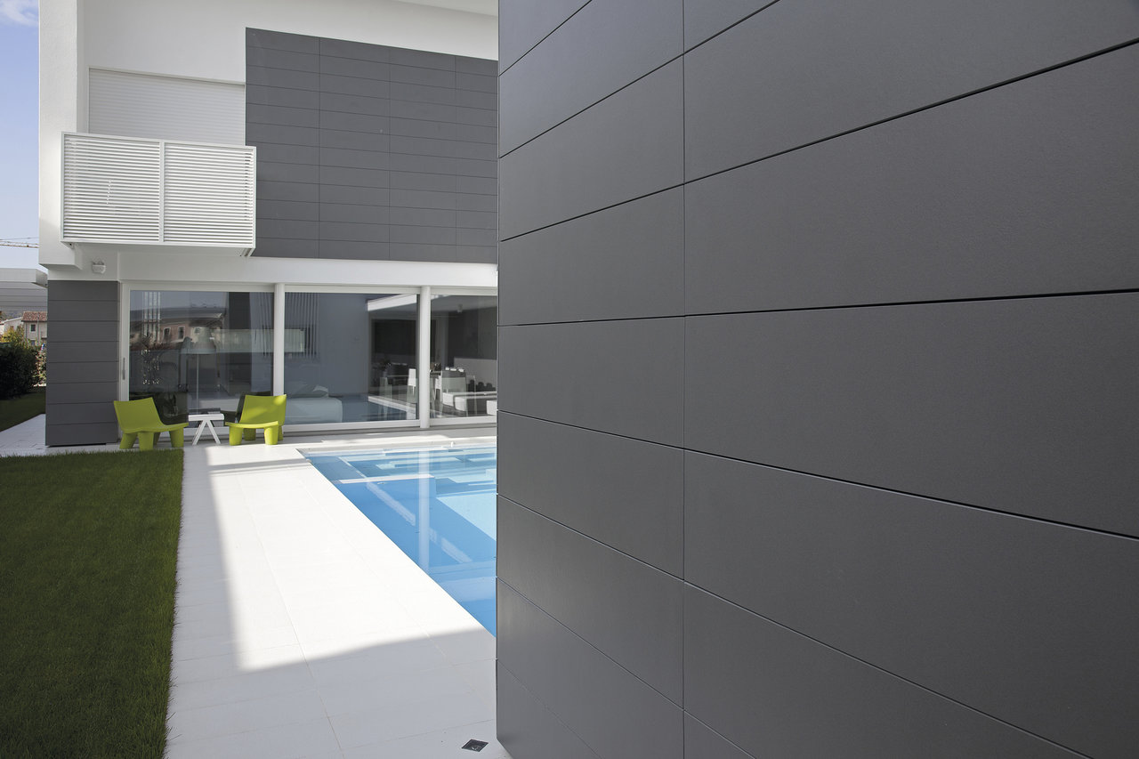 Dark grey outdoor tiles on a modern house facade and pool surround.