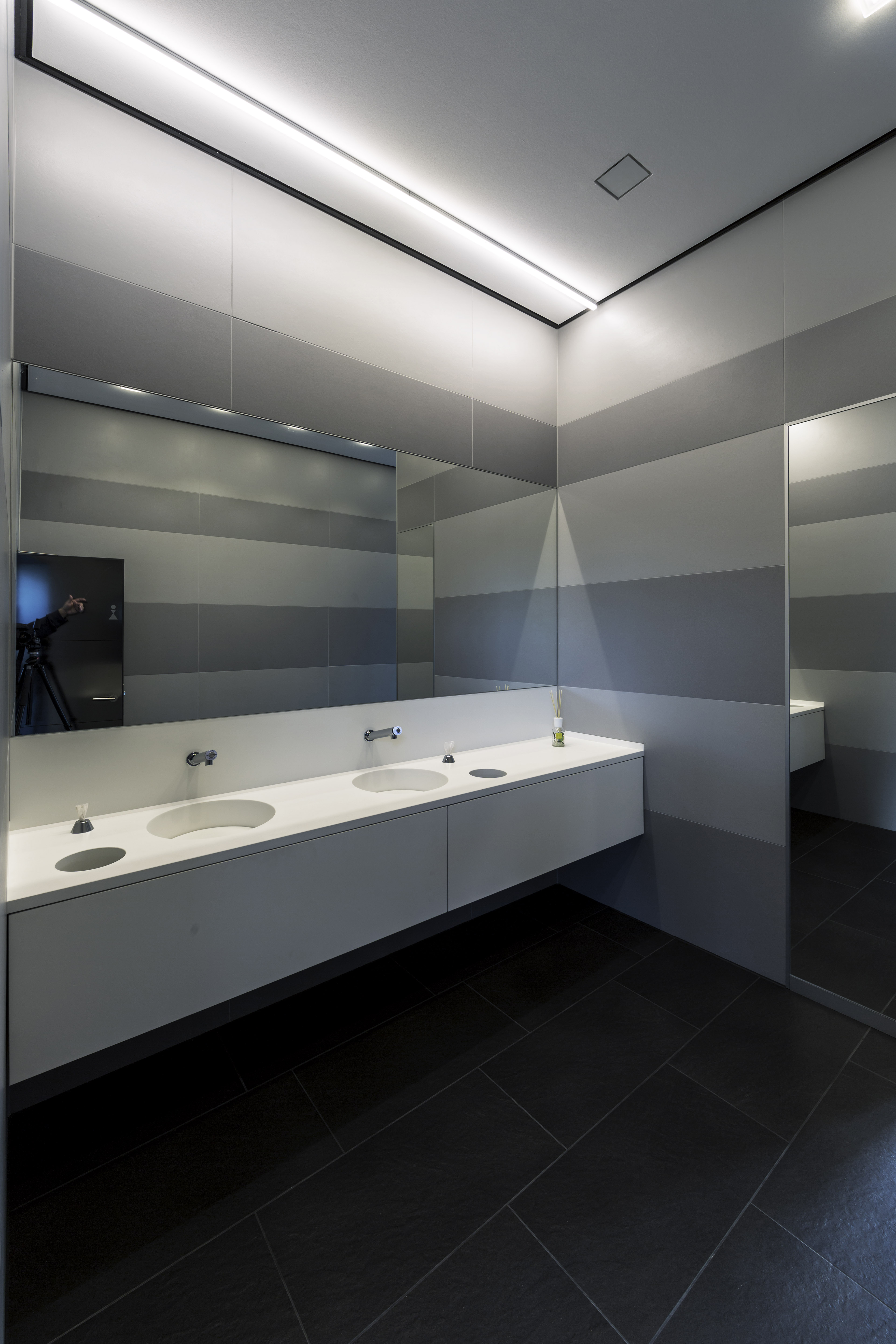 High-quality black floor tiles in a modern bathroom with double vanity.