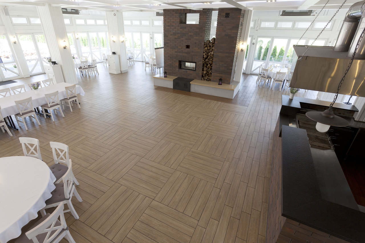 Spacious hall with light wood-look porcelain tiles and striking laying pattern.