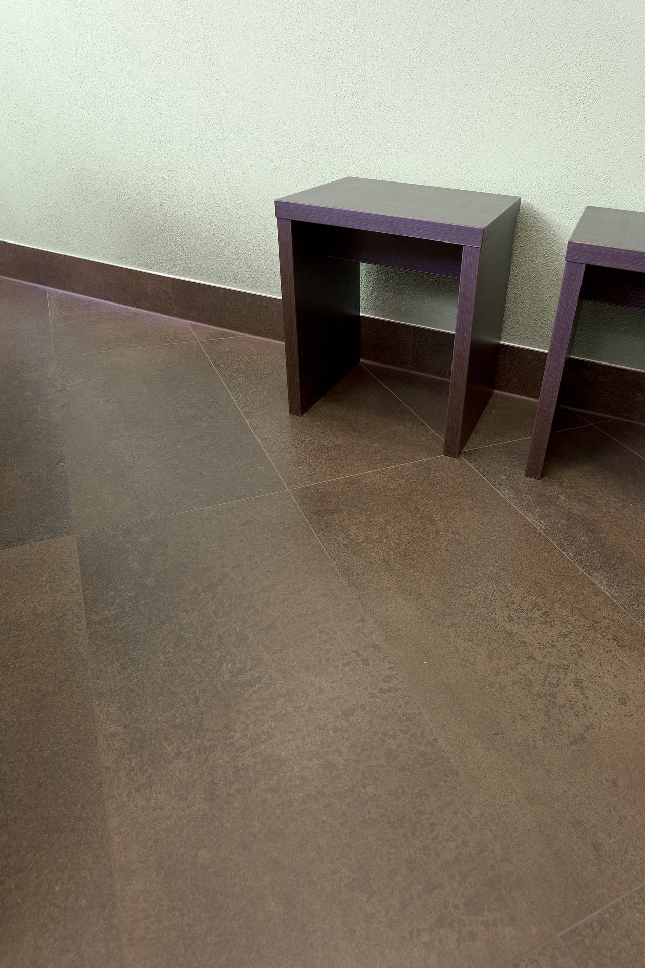 Dark brown stone-effect floor tiles with a matte finish.