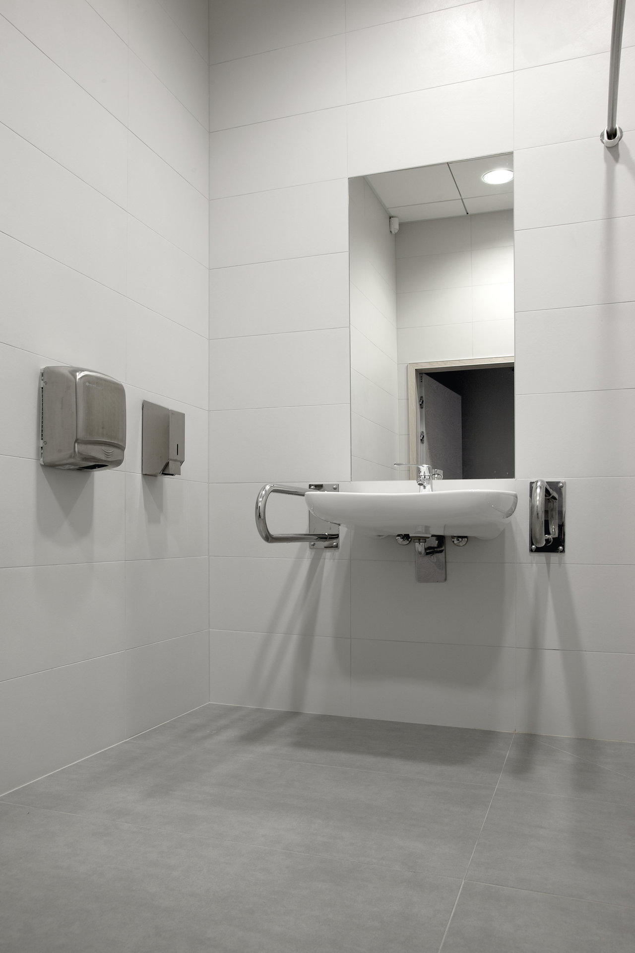 Modern bathroom with high-quality white wall and grey floor tiles.