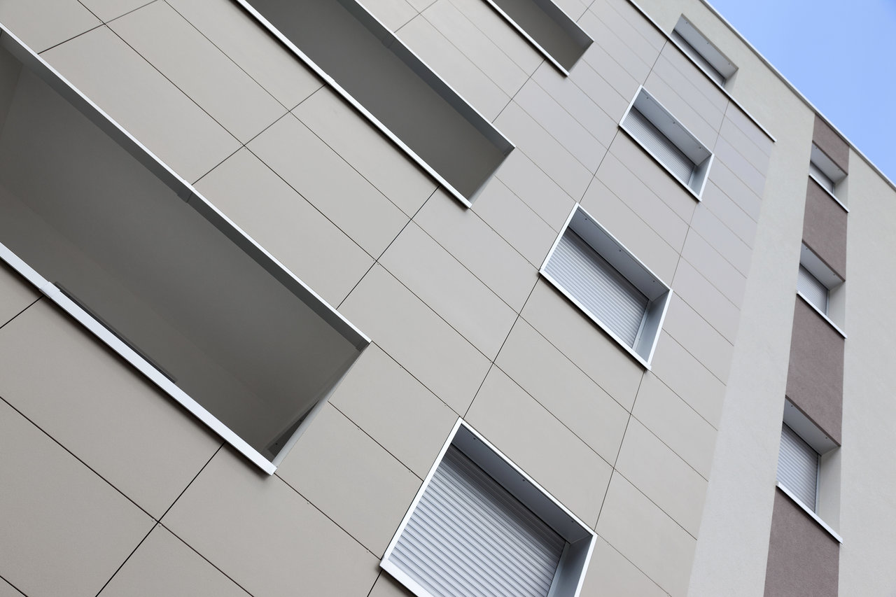 Building facade with light, large-format outdoor tiles.