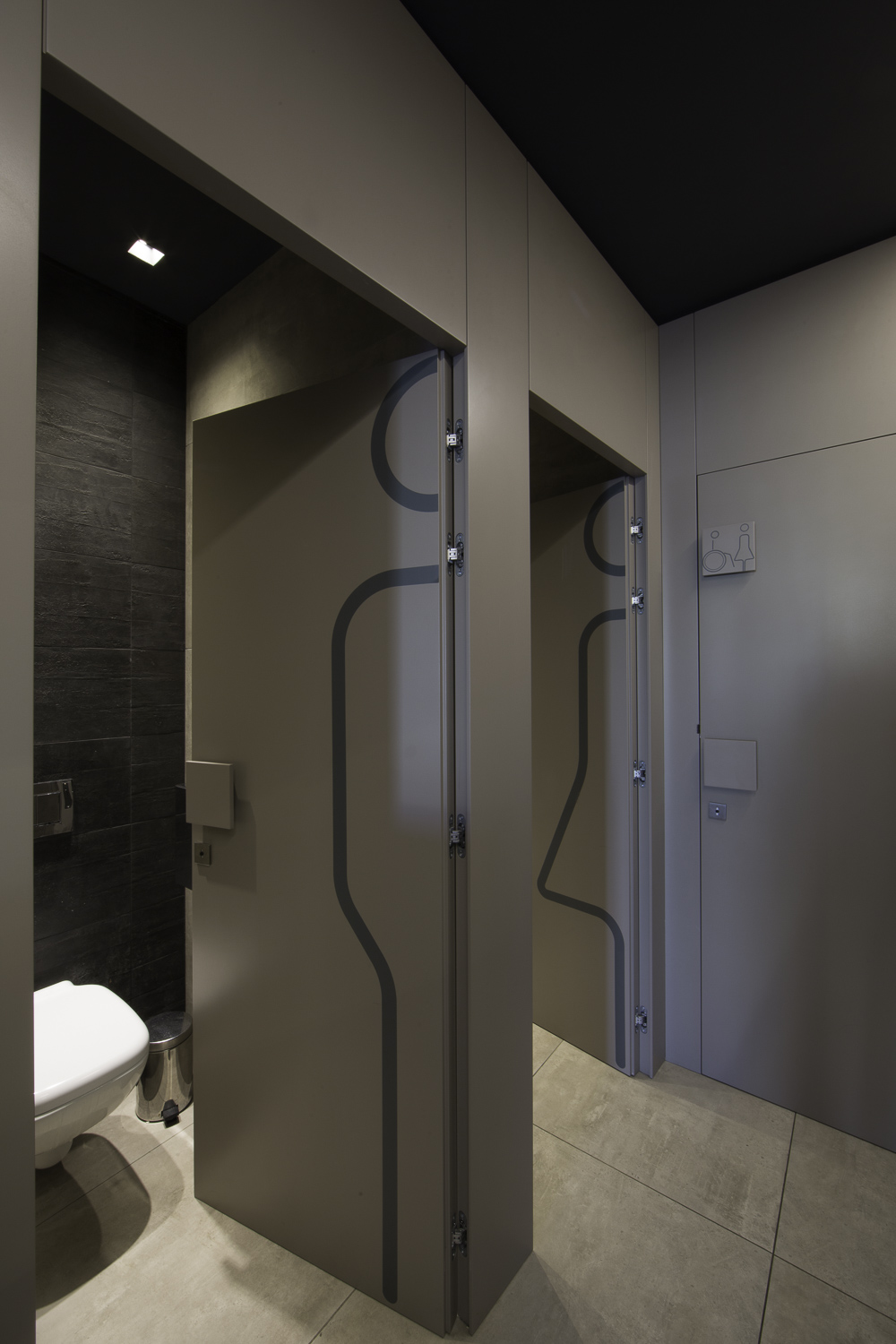 Modern WC with premium dark wall and light floor tiles.