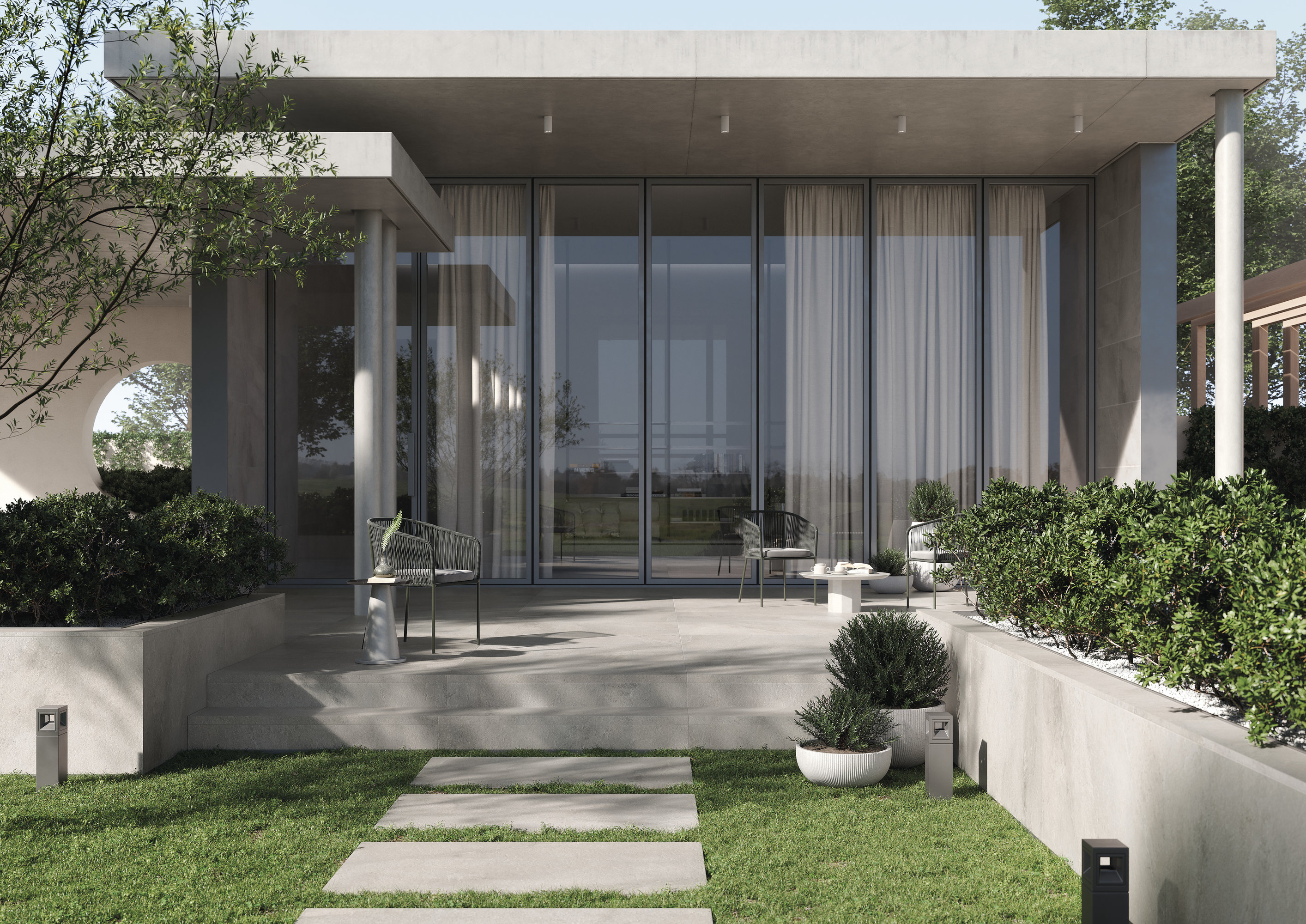 Modern patio with large-format outdoor tiles and stepping stones in the garden.