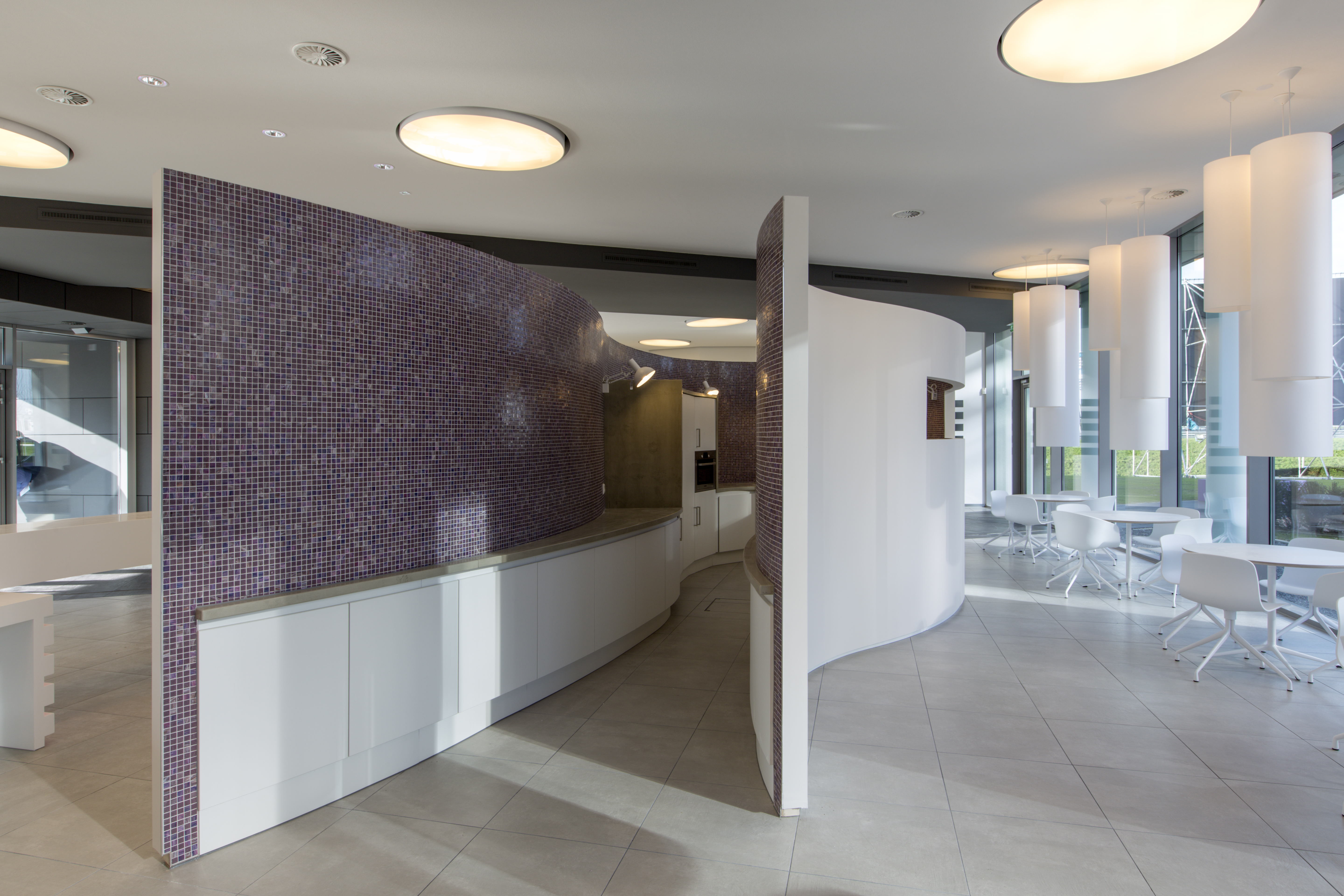 Modern interior with purple mosaic wall and light floor tiles.
