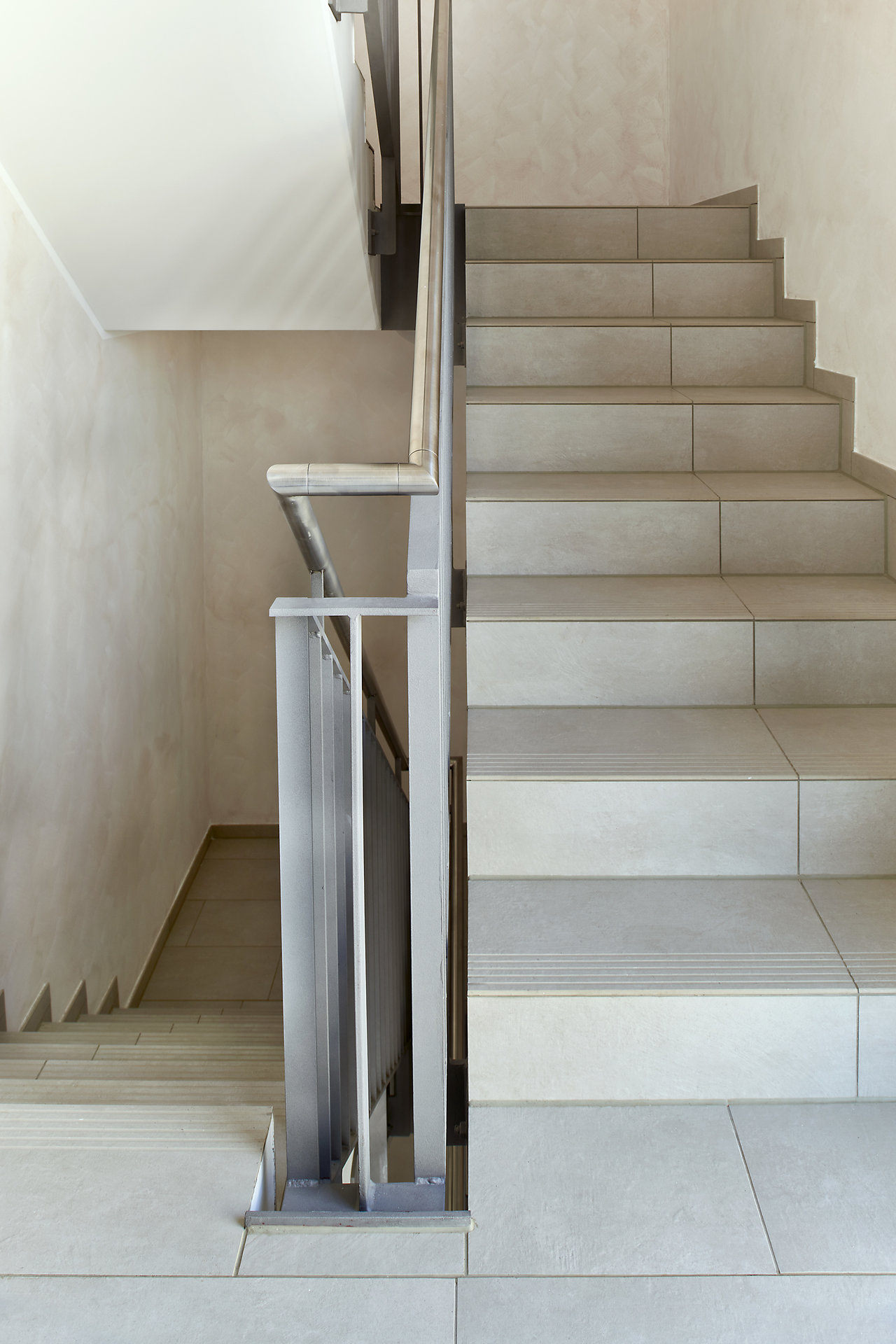 Modern staircase with bright, high-quality tiles, ideal for stylish interiors.
