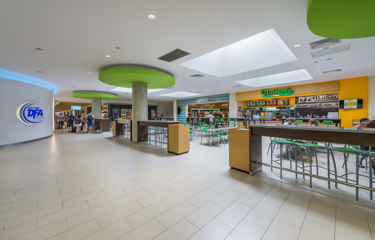 Light rectangular floor tiles in modern shopping arcade with dining.