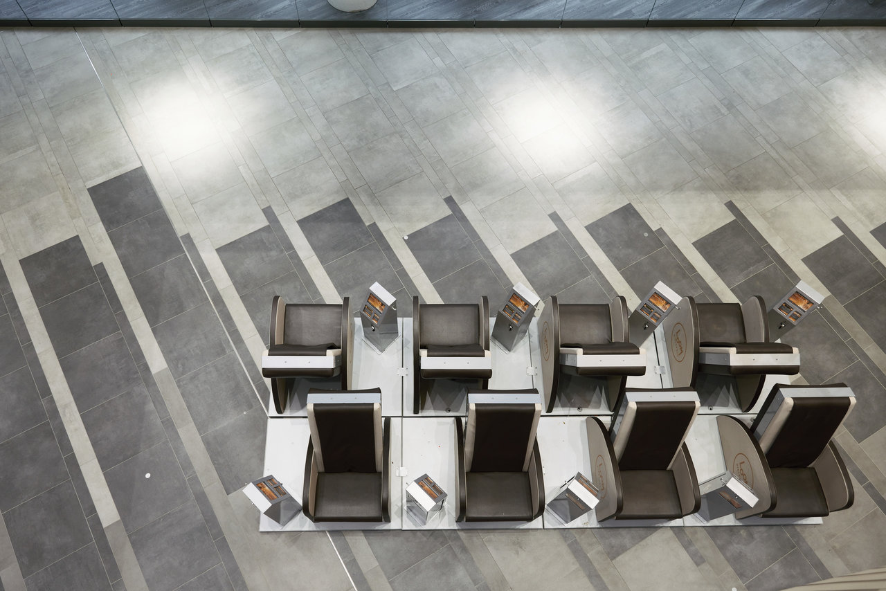 Grey tiled floor with geometric pattern, elegant seating, and striking shadows.
