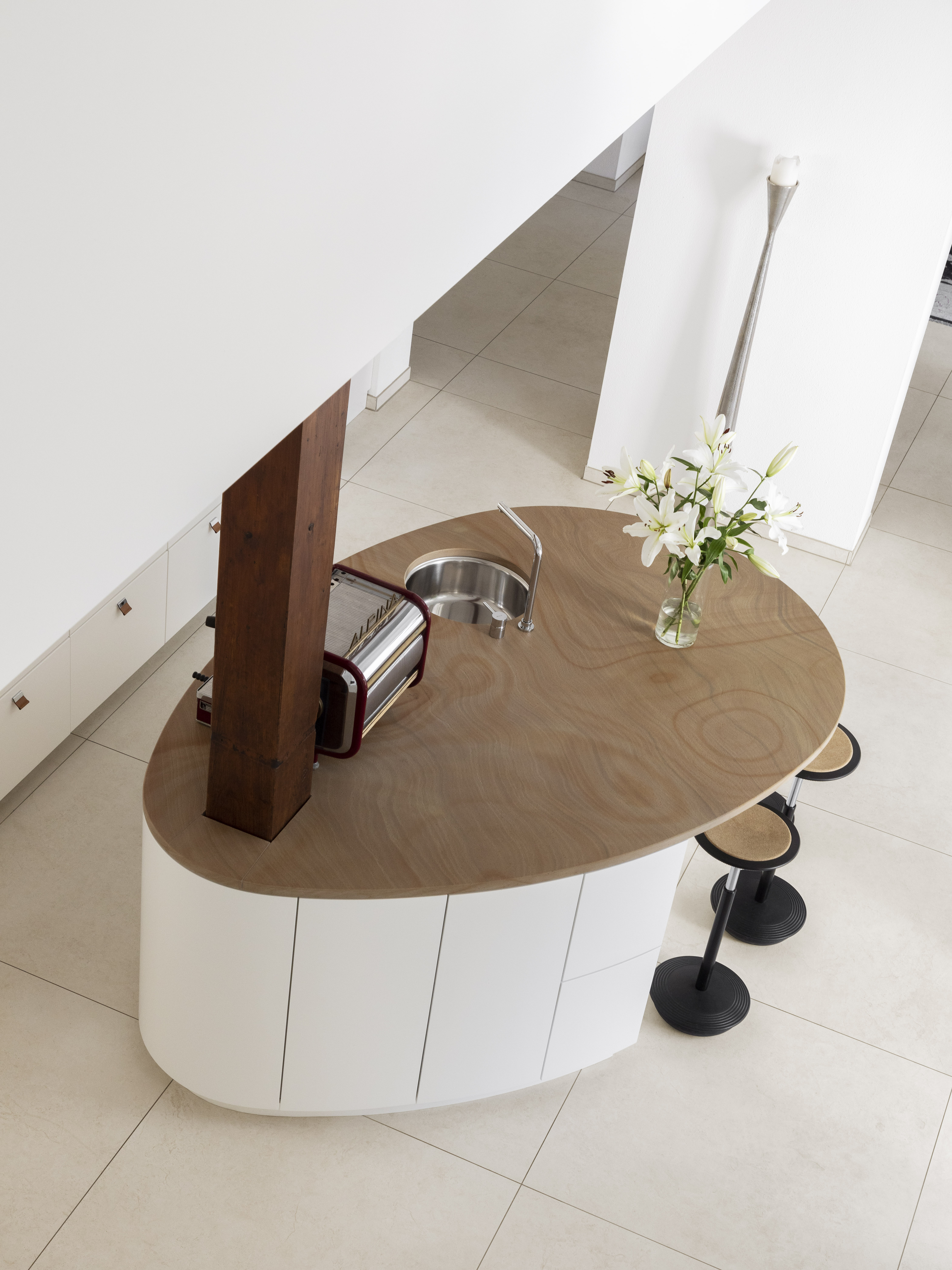 High-quality, light floor tiles in a stylish kitchen with an oval island.