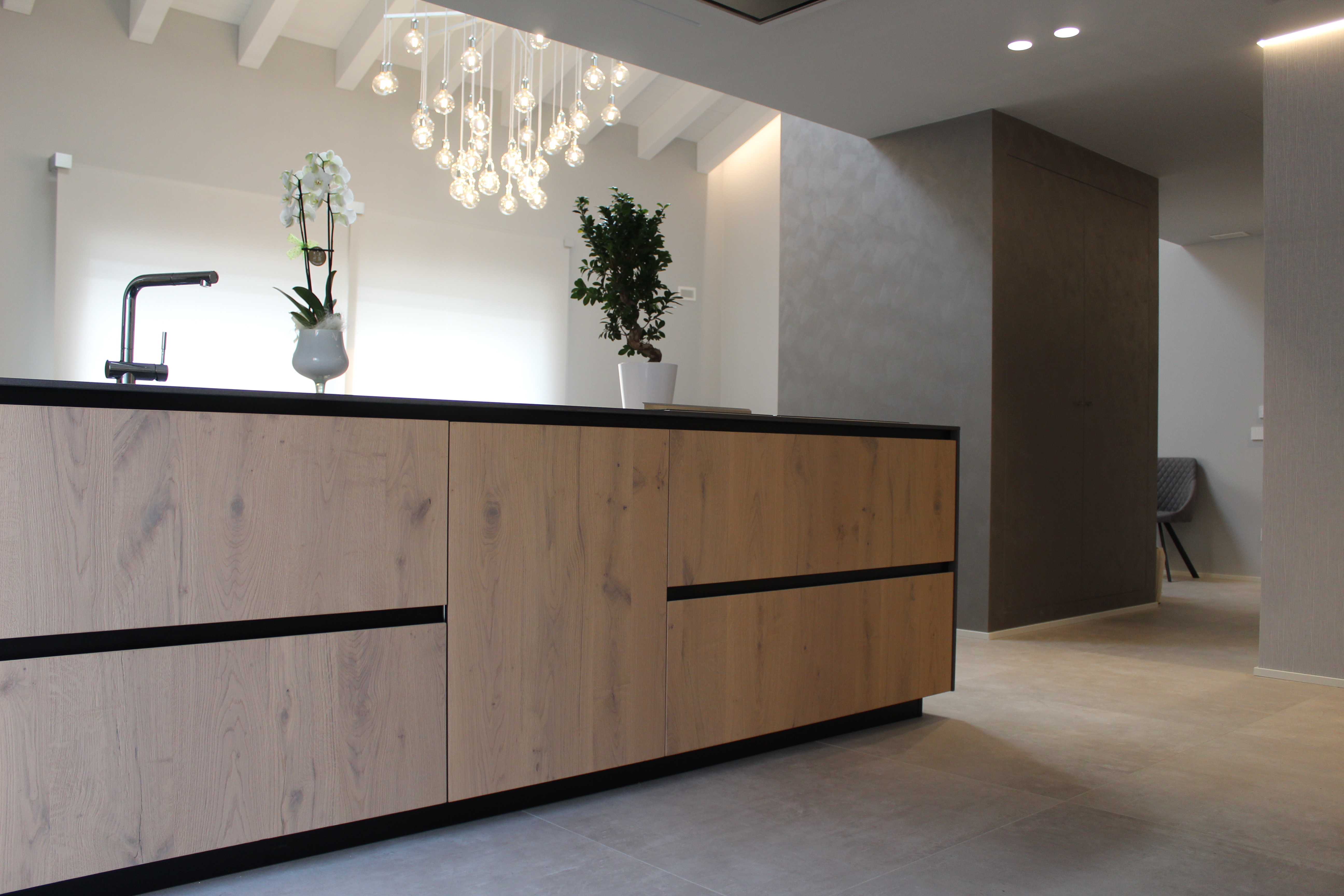 Modern kitchen with high-quality tile floor and an island with wood fronts.