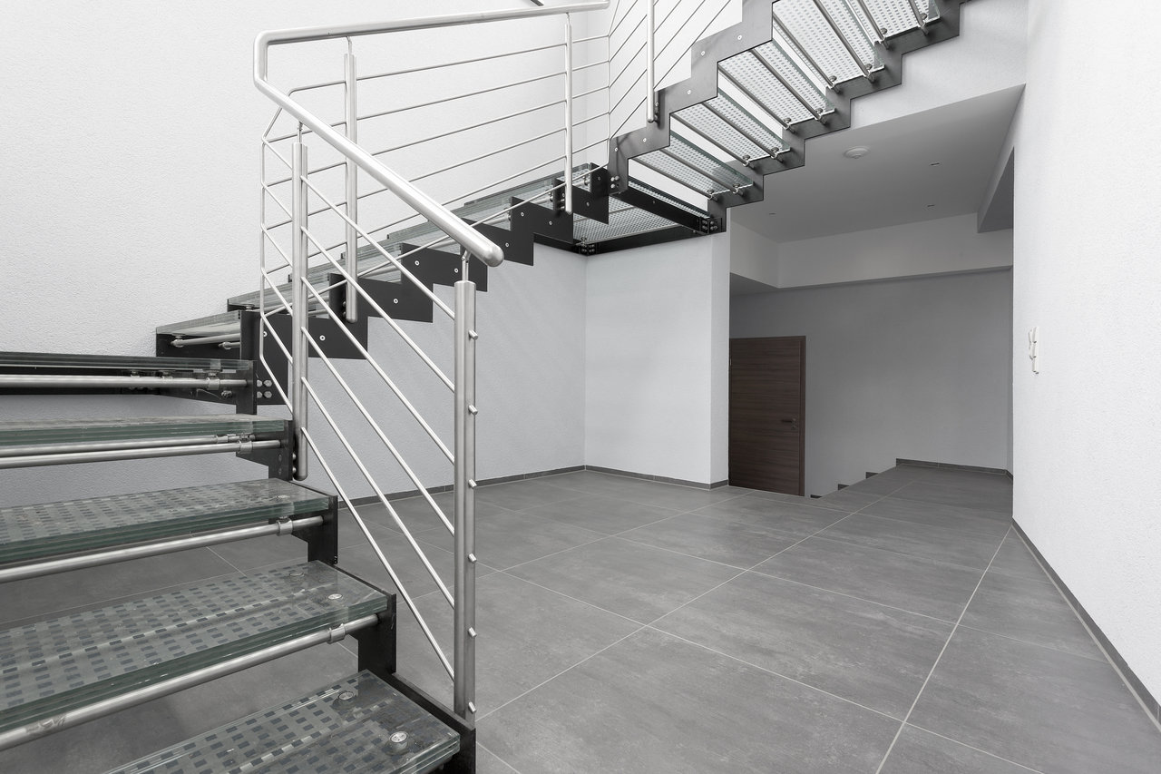 Large-format, anthracite indoor tiles in a modern staircase.
