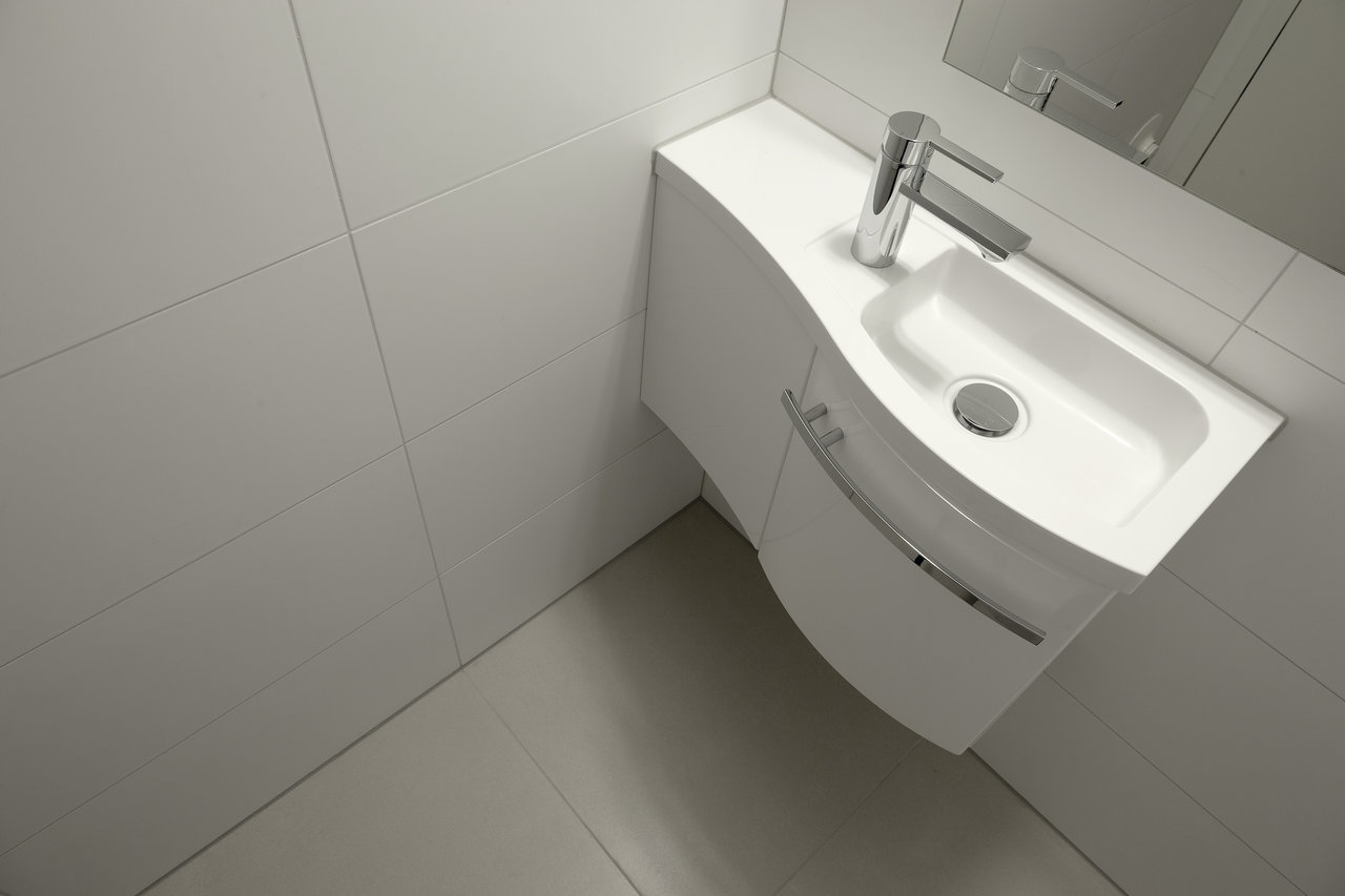 Plain white wall and light grey floor tiles in a modern bathroom.