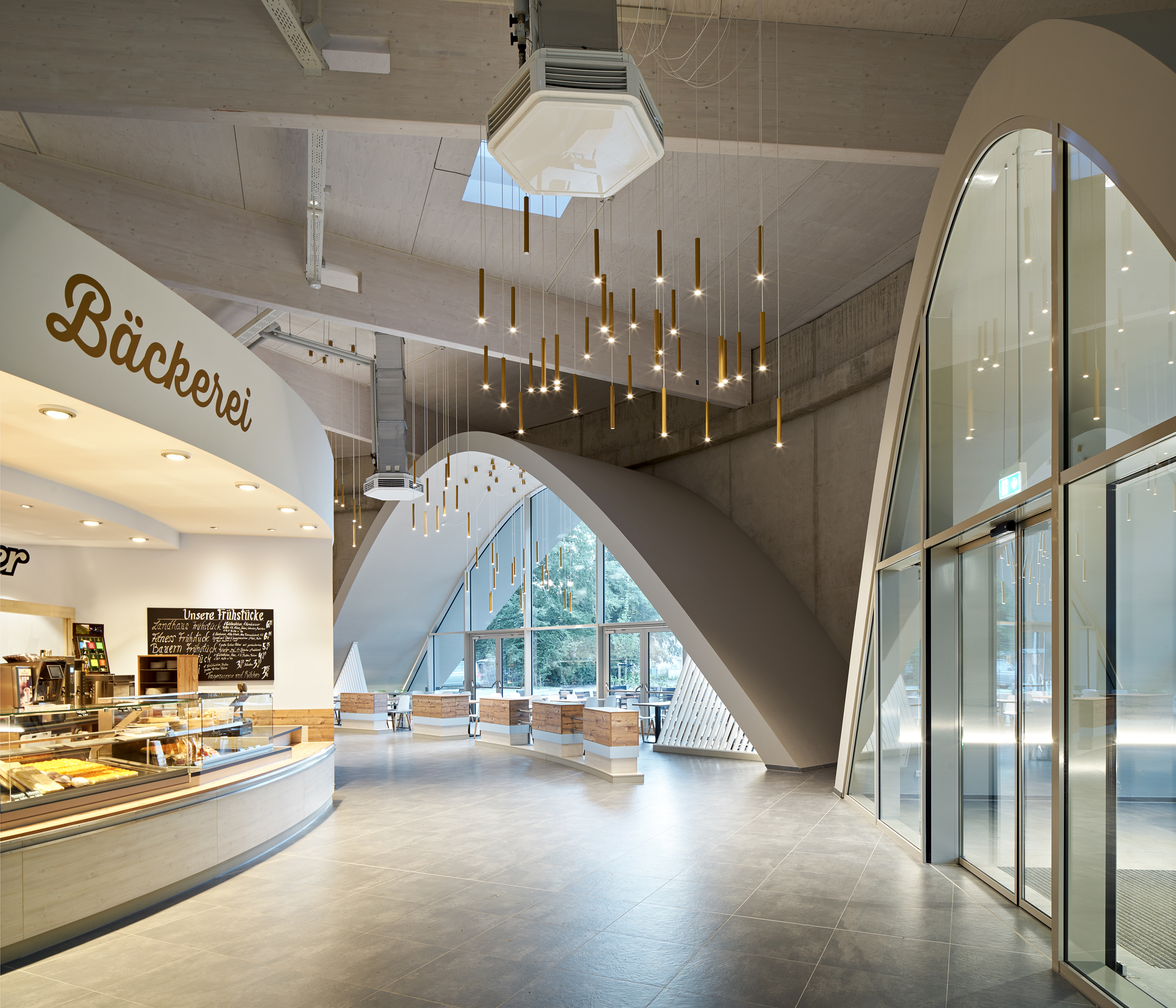 Spacious, bright room with a bakery and modern, large-format tiled floor.