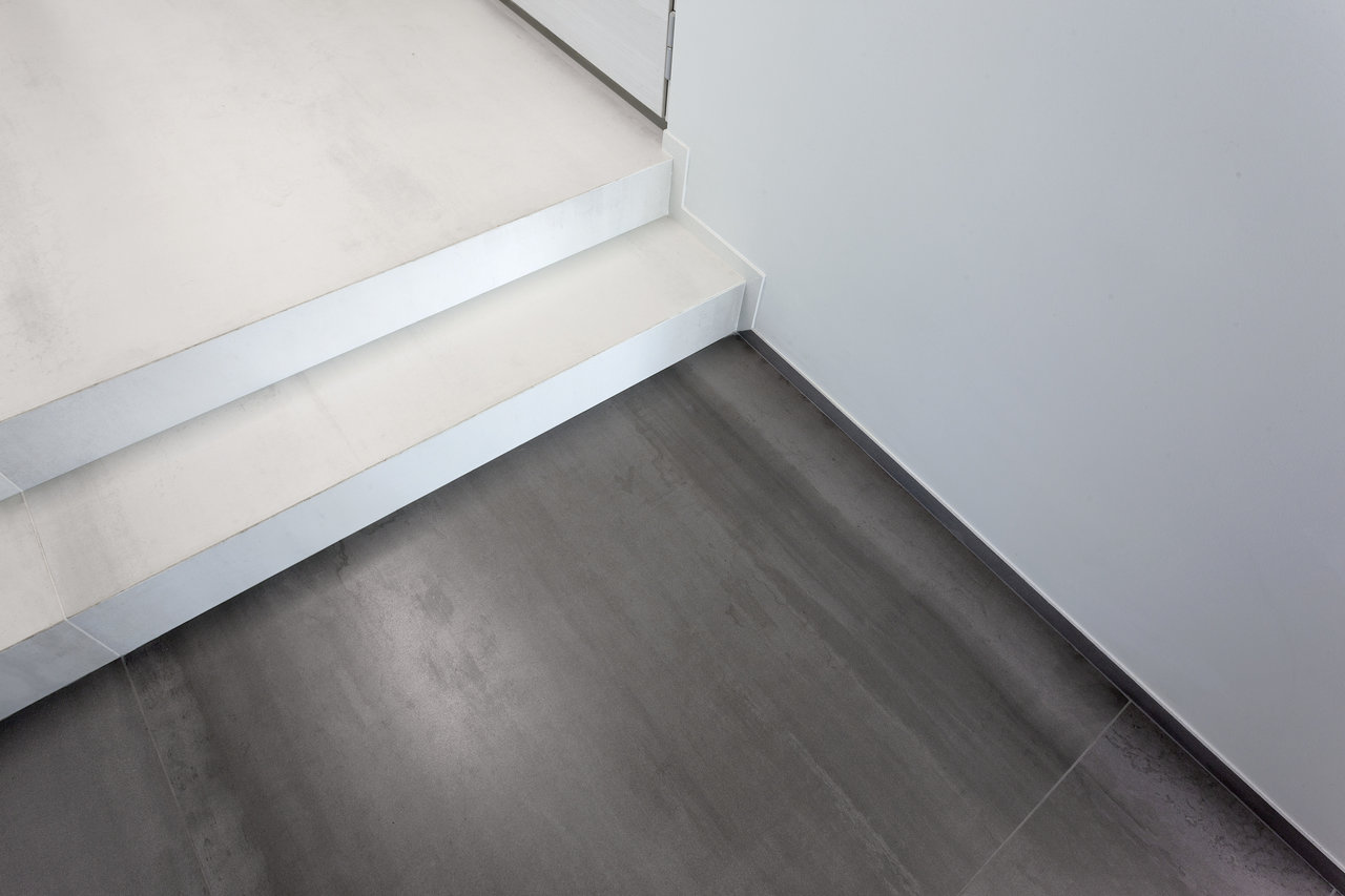 High-quality tiles: Dark floor tiles and light step tiles with modern metal edges.